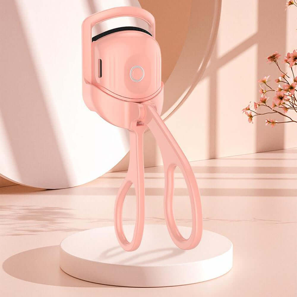Portable electric heated eyelash curler in pink color, designed for quick and easy lash curling.