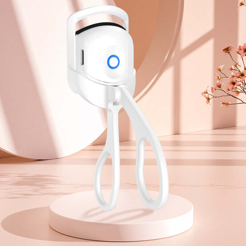 Portable electric eyelash curler with a sleek design, featuring a blue indicator button and ergonomic handles.