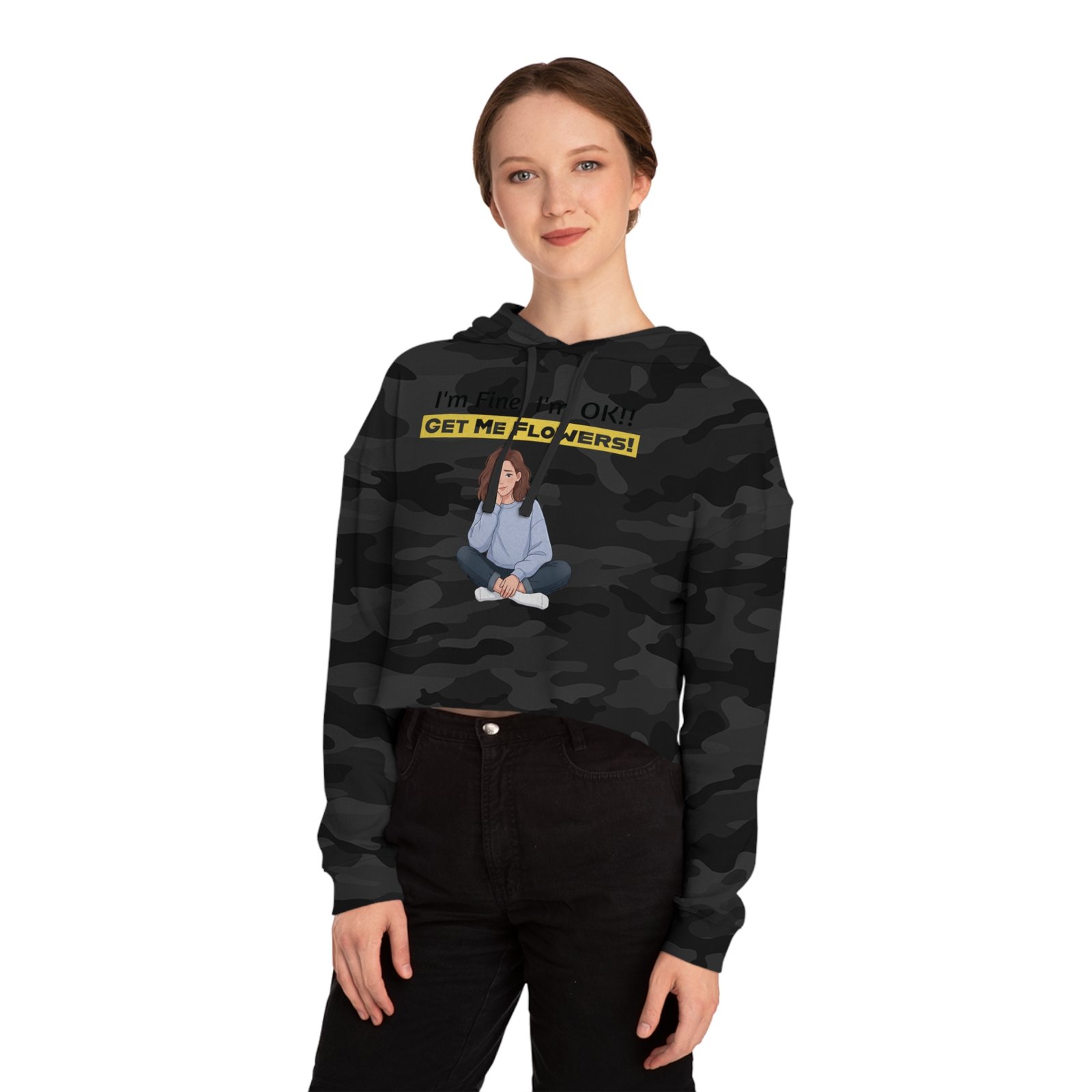 Woman wearing a camouflage cropped hoodie featuring a graphic of a girl and the text "I'm Fine! I'm OK!! GET ME FLOWERS!"