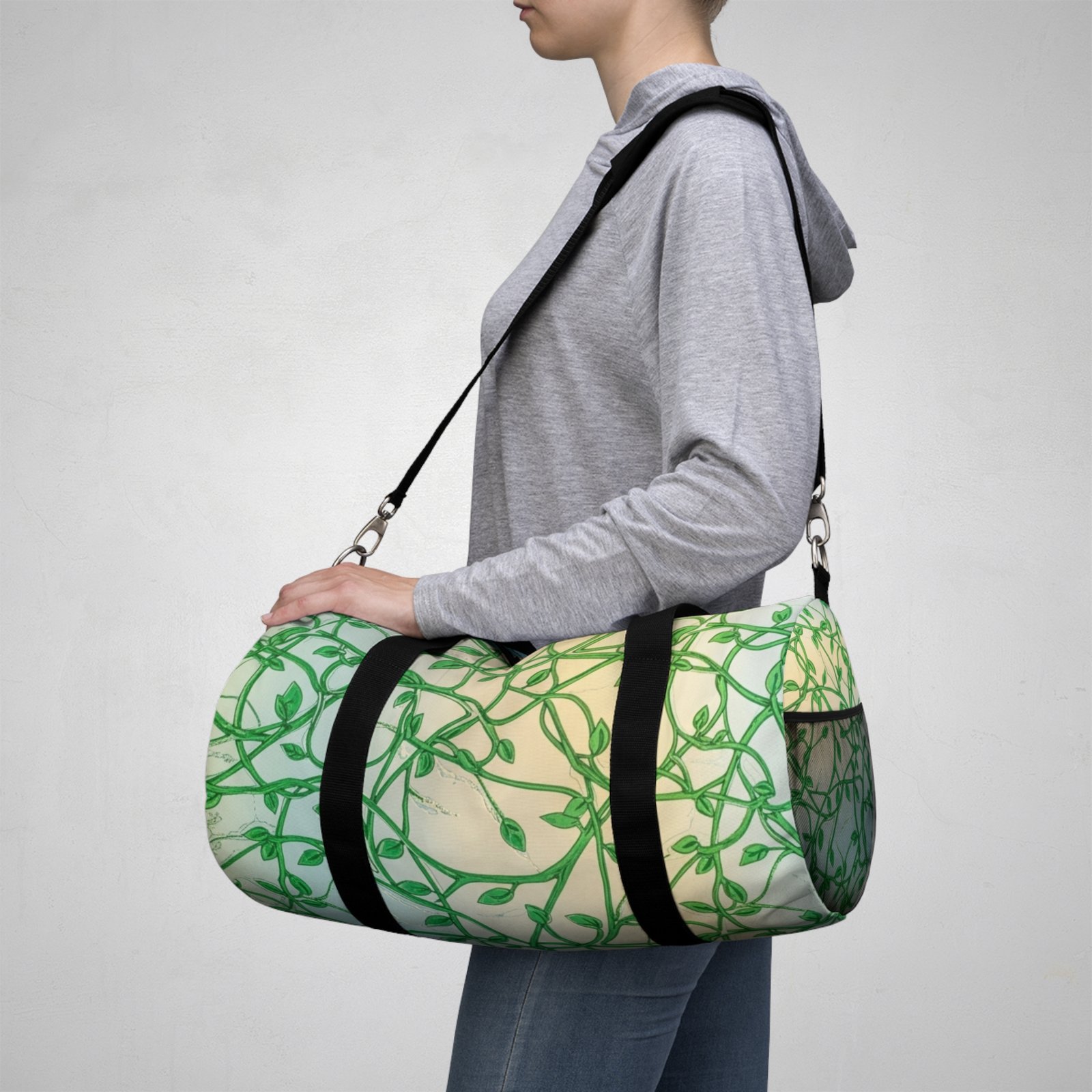 A person carries a Green Vines Pattern Duffel Bag with a botanical leaf design and a black shoulder strap.