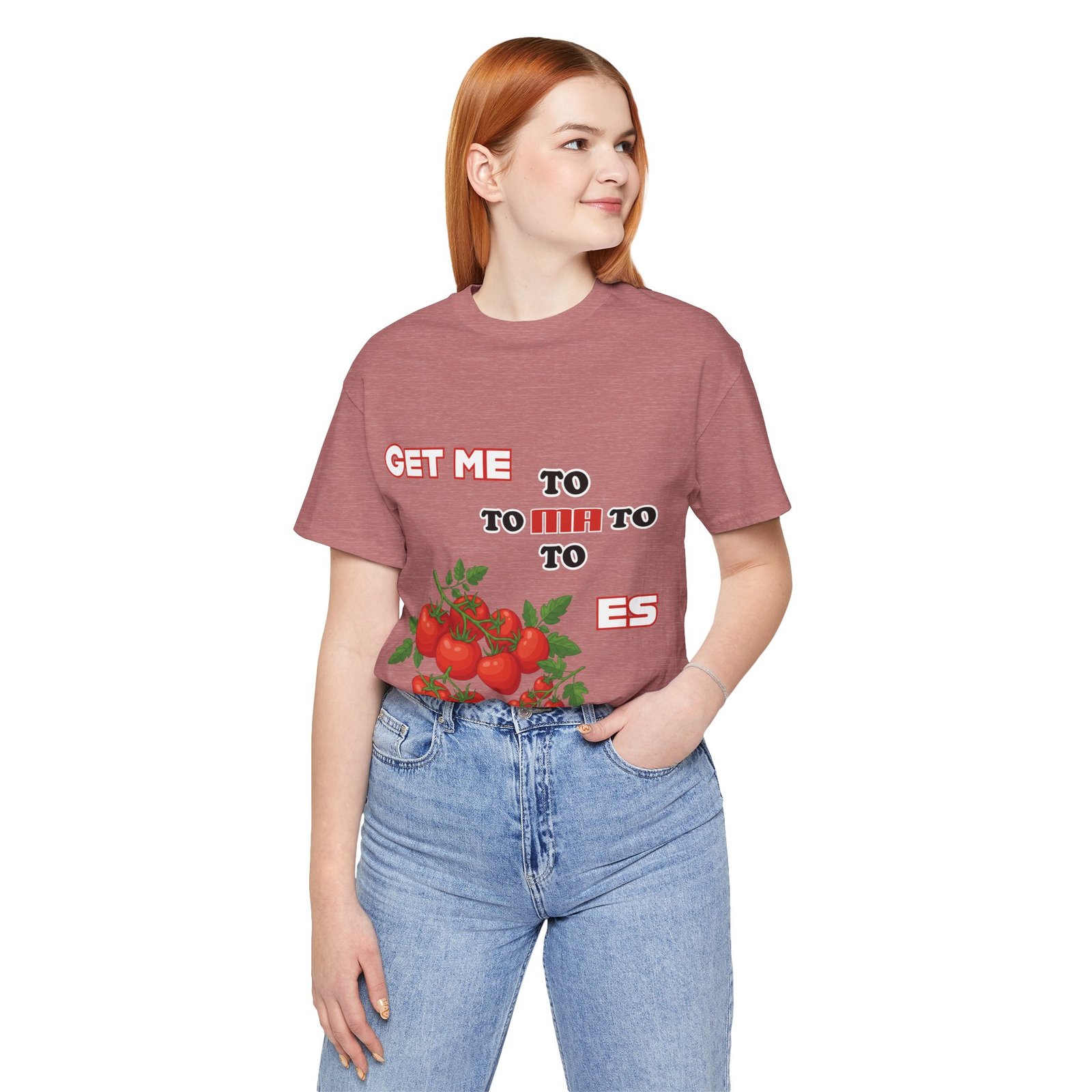 A woman wearing a dusty rose t-shirt featuring a whimsical tomato illustration and 'Get Me To Ma To Toes' text.