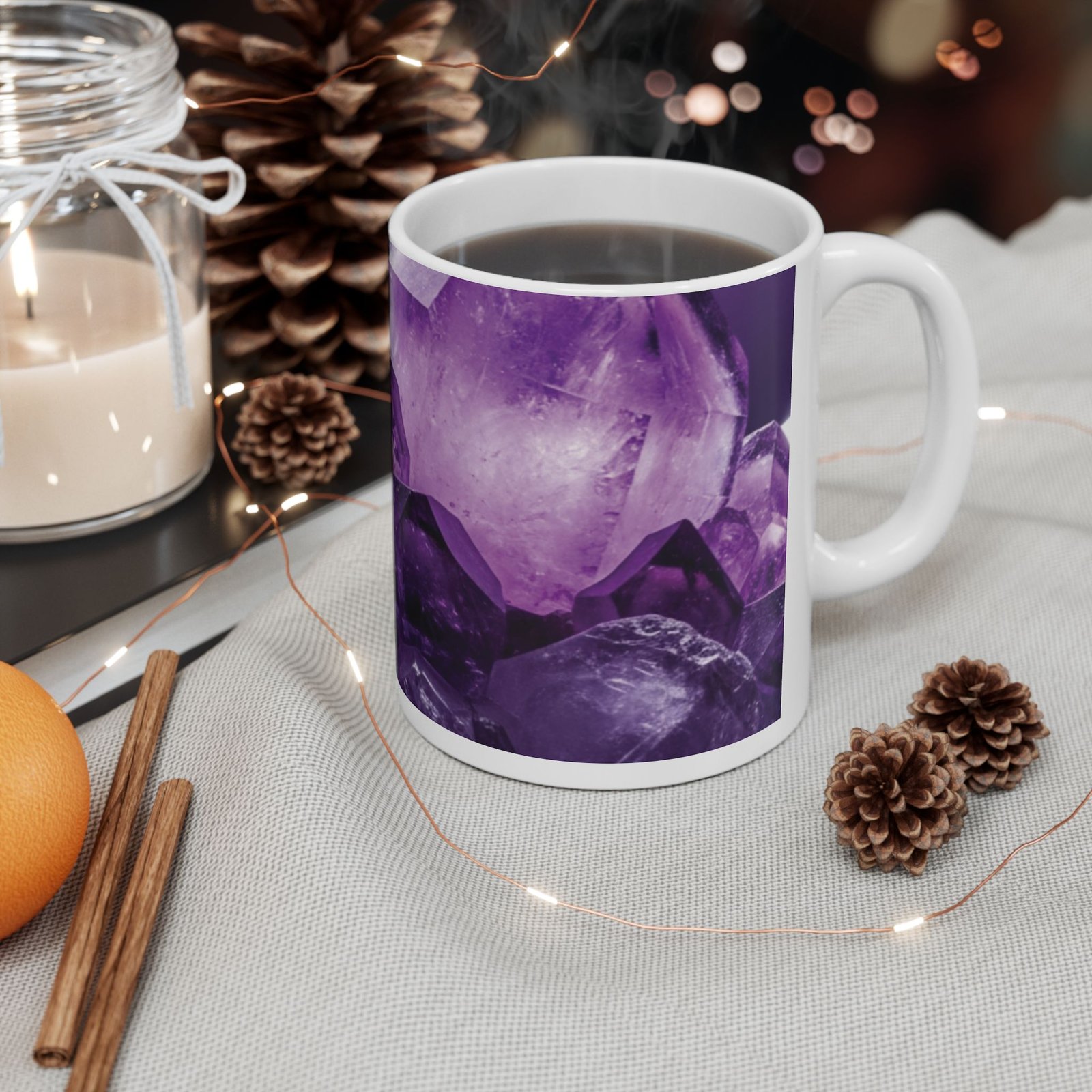 Amethyst crystal ceramic mug featuring a deep purple gemstone print next to pinecones and a candle.