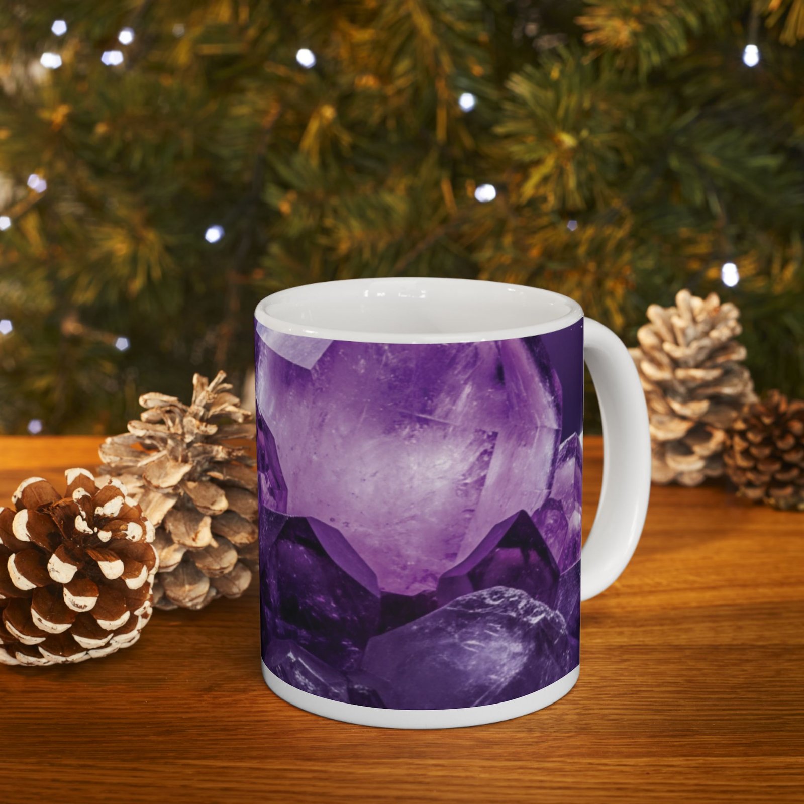 Amethyst crystal ceramic mug with a vivid purple gemstone print, sitting on a wooden surface next to pinecones.