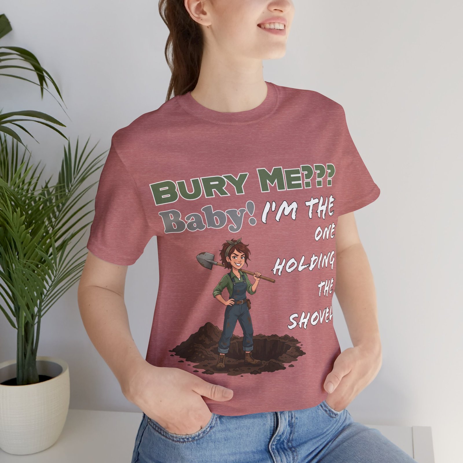 Dusty rose t-shirt featuring an illustration of a character with a shovel and the dark humor text "BURY ME??? Baby! I'm the ONE HOLDING THE SHOVEL".