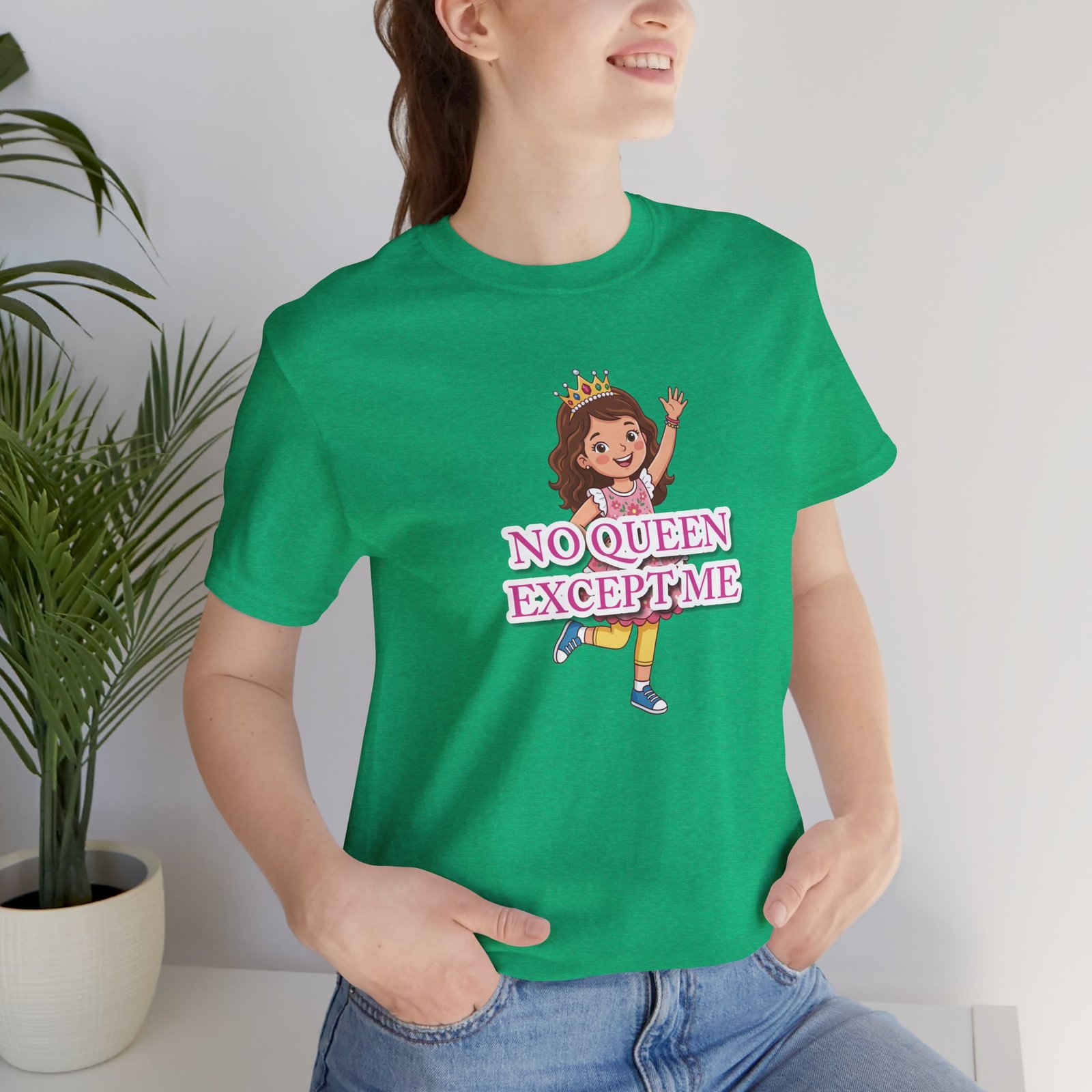 Girl wearing a green No Queen Except Me T-shirt with a whimsical illustration of a little queen wearing a crown.
