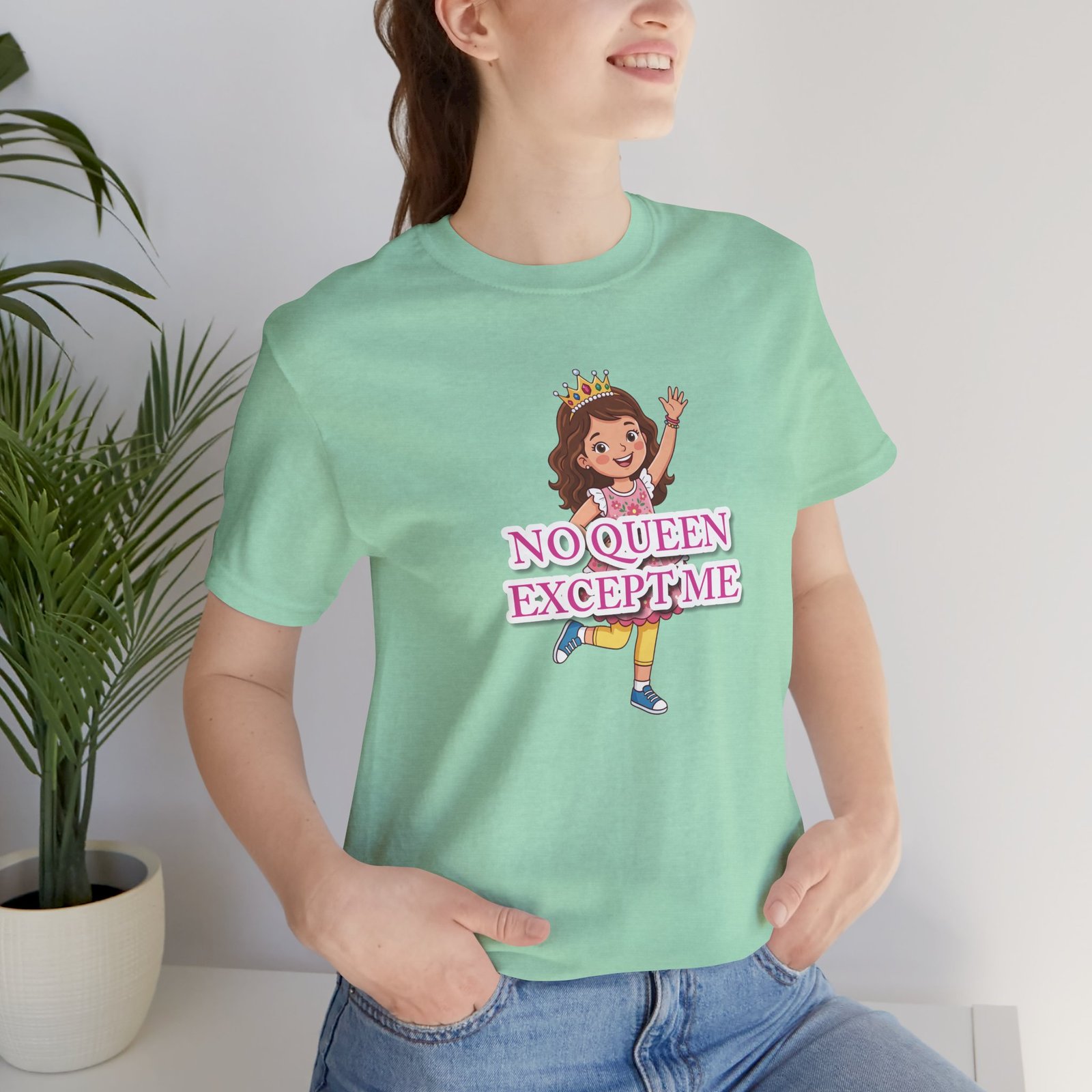 Girl wearing a mint green "No Queen Except Me" T-shirt featuring a whimsical illustration of a little queen wearing a crown.