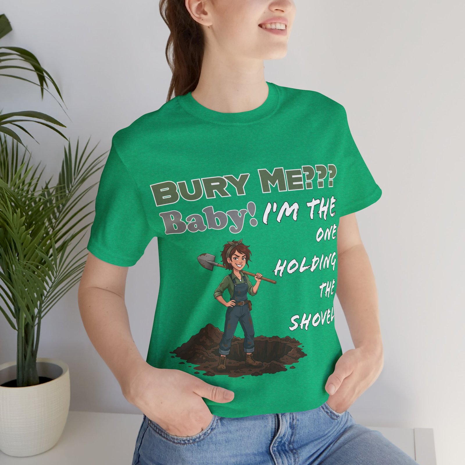 Green crew neck t-shirt featuring a dark humor illustration of a character with a shovel and the text Bury Me??? Baby!