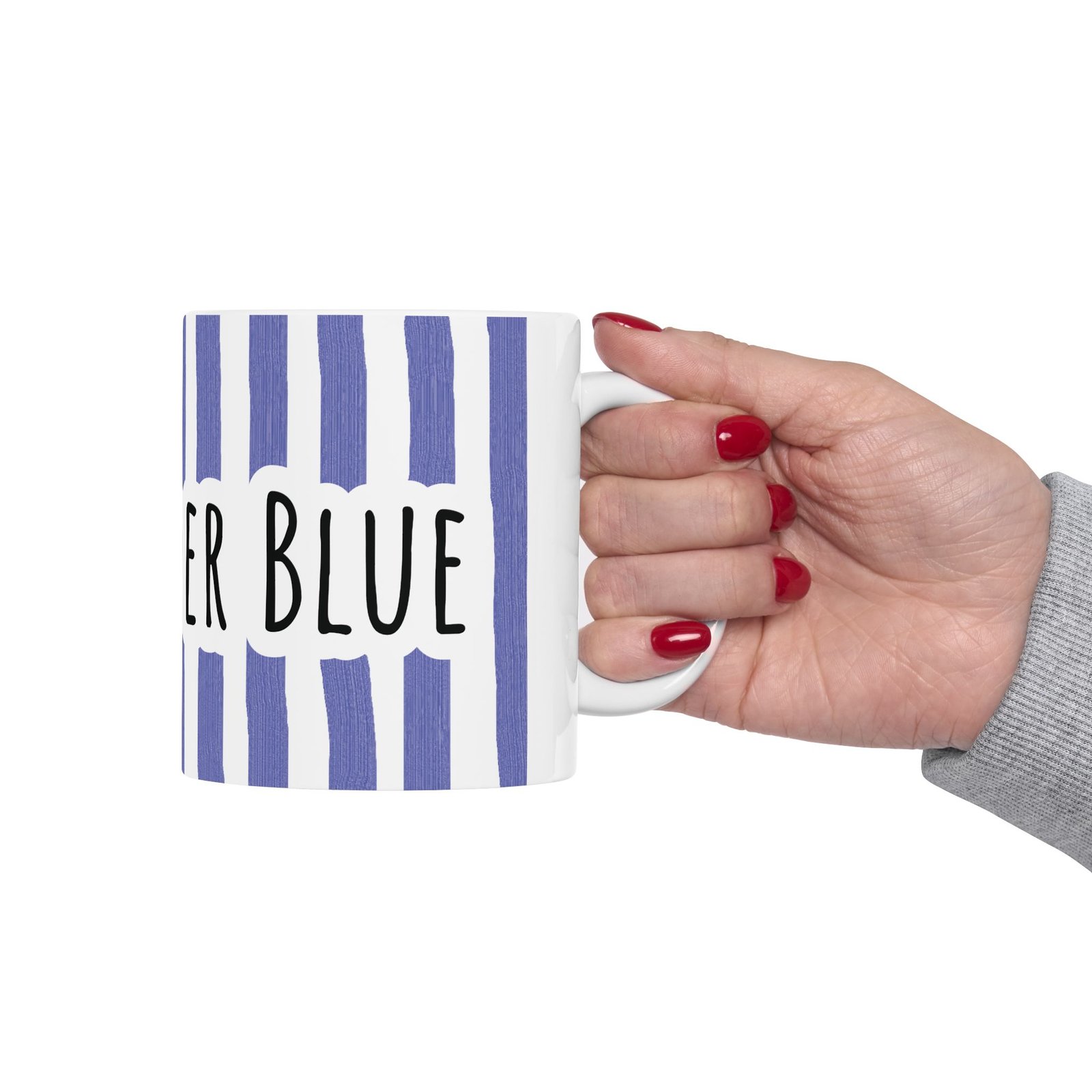 Hand holding a white glossy ceramic mug featuring periwinkle blue vertical brushstroke stripes and 'STAY BLUE' text.