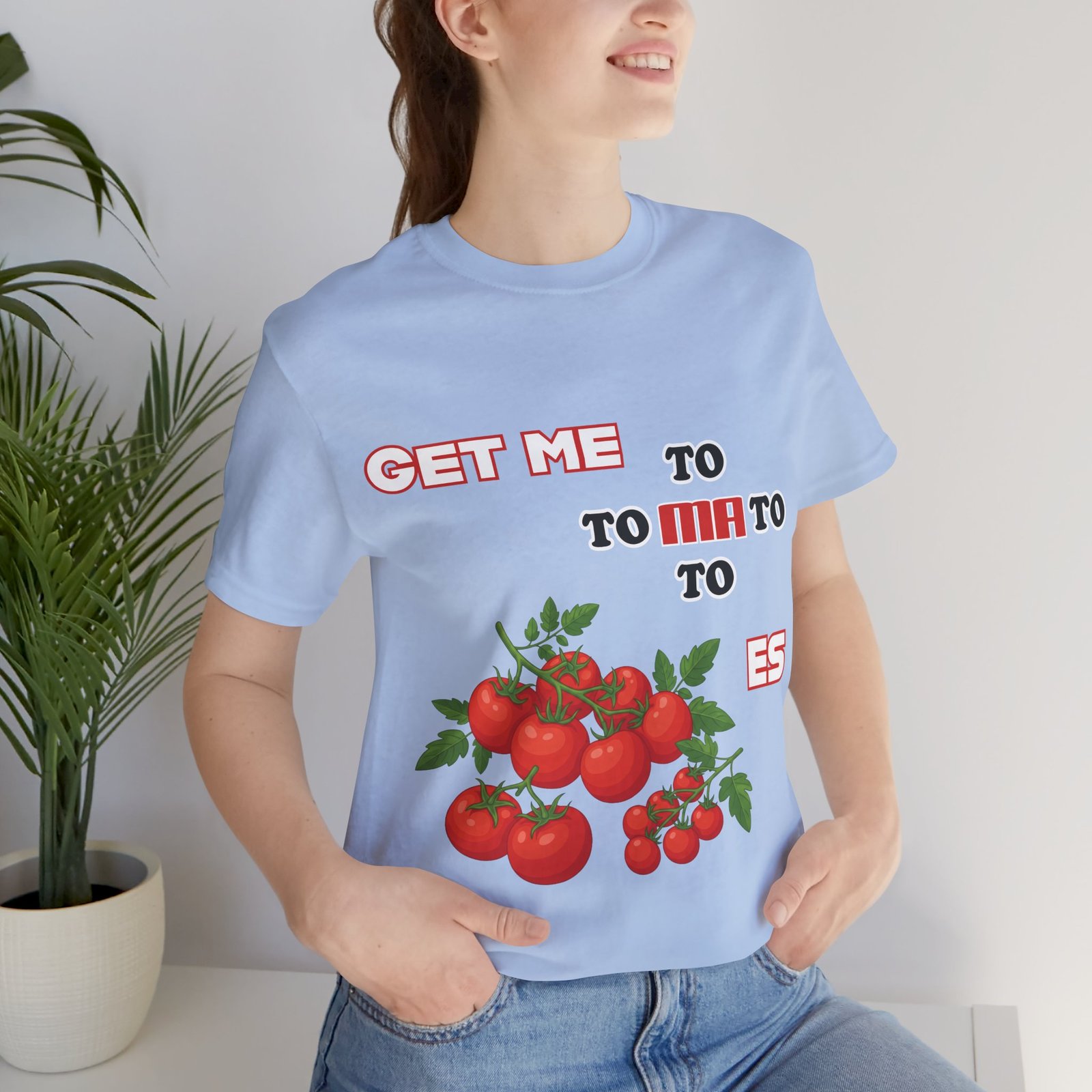 Light blue crewneck t-shirt featuring a whimsical tomato illustration and the fragmented phrase Get Me To Ma To Toes.