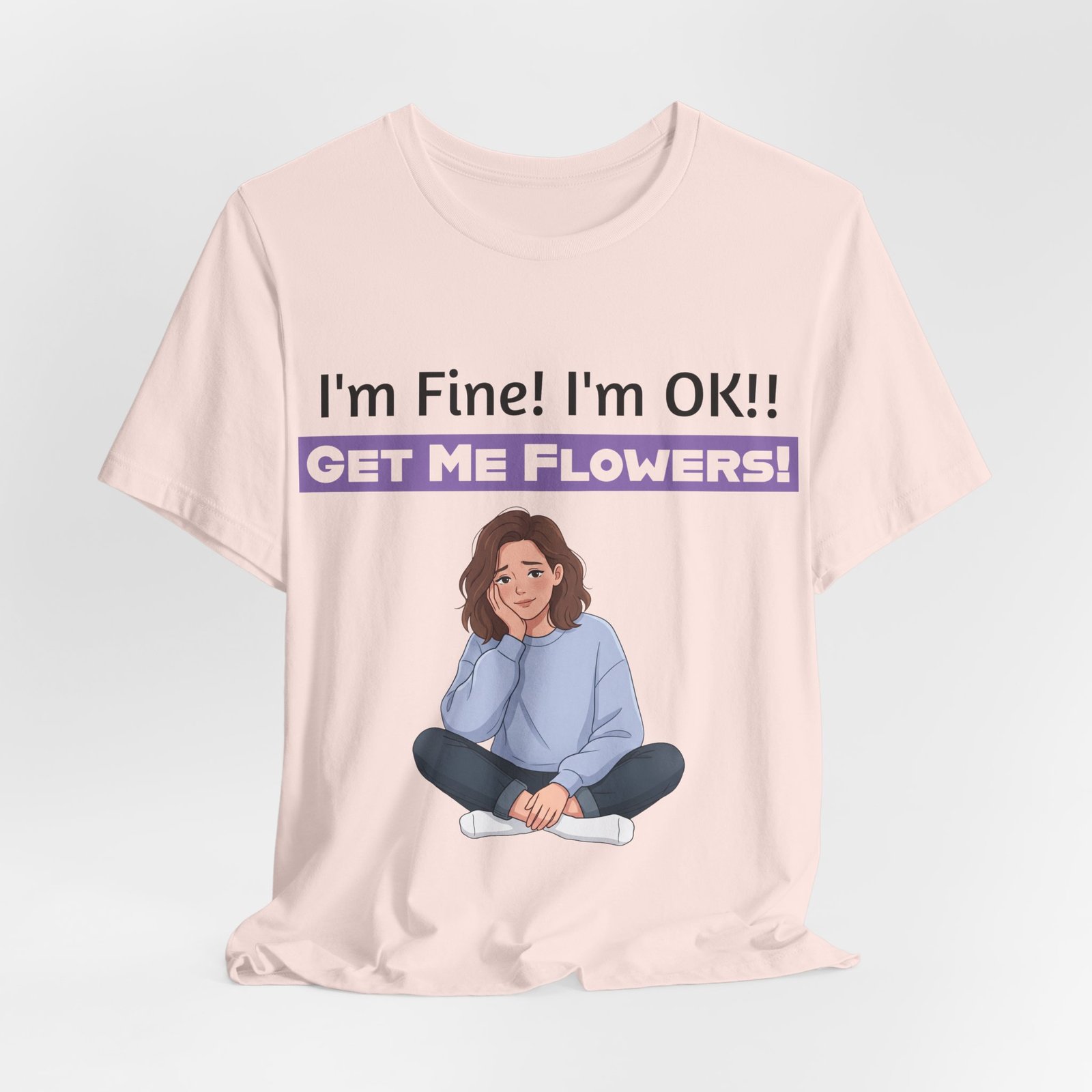 Light pink funny T-shirt with 'I'm Fine! I'm OK!! GET ME FLOWERS!' text and illustration of a girl sitting cross-legged.