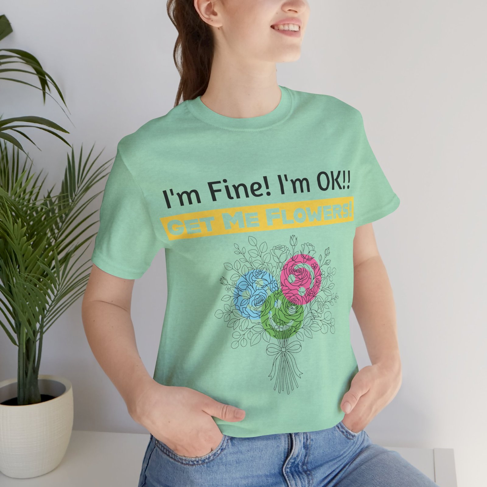Mint green cotton t-shirt featuring the funny text I'm Fine! I'm OK!! GET ME FLOWERS! above a colorful floral bouquet.