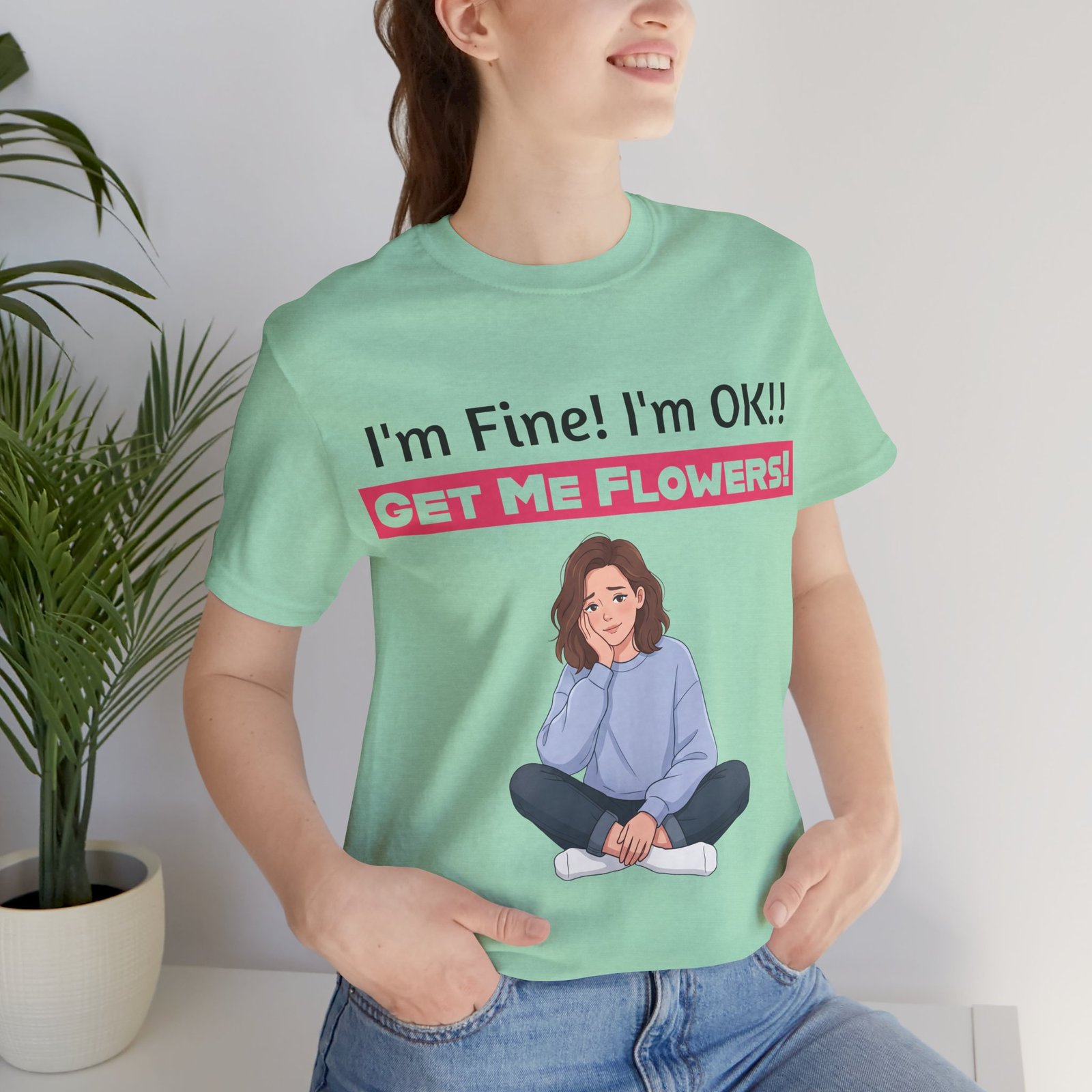 Mint green t-shirt with 'I'm Fine! I'm OK!! GET ME FLOWERS!' text and an illustration of a seated woman.