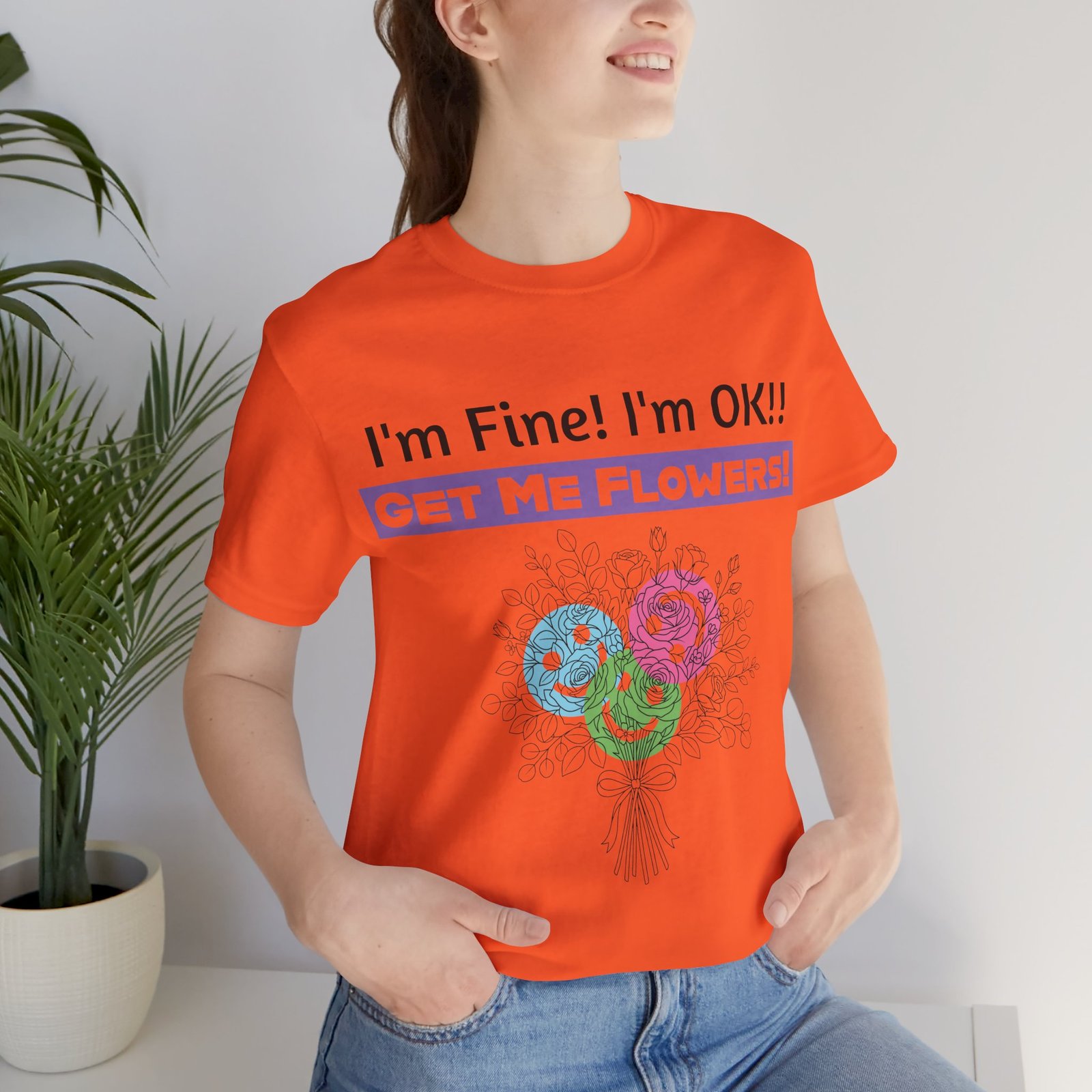 Orange t-shirt with sarcastic text "I'm Fine! I'm OK!! GET ME FLOWERS!" and colorful floral bouquet graphic.