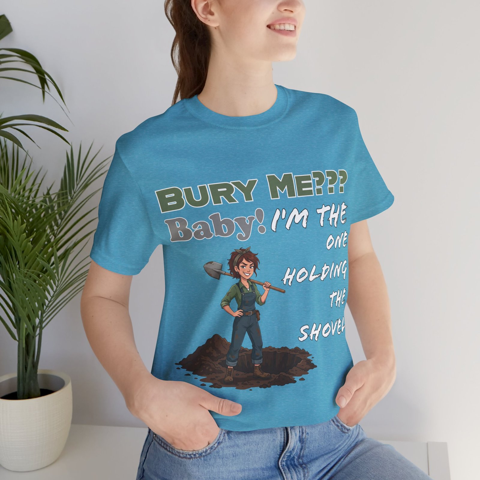 Person wearing a blue "Bury Me??? Baby! I'm the One Holding the Shovel" t-shirt featuring a dark humor illustration.