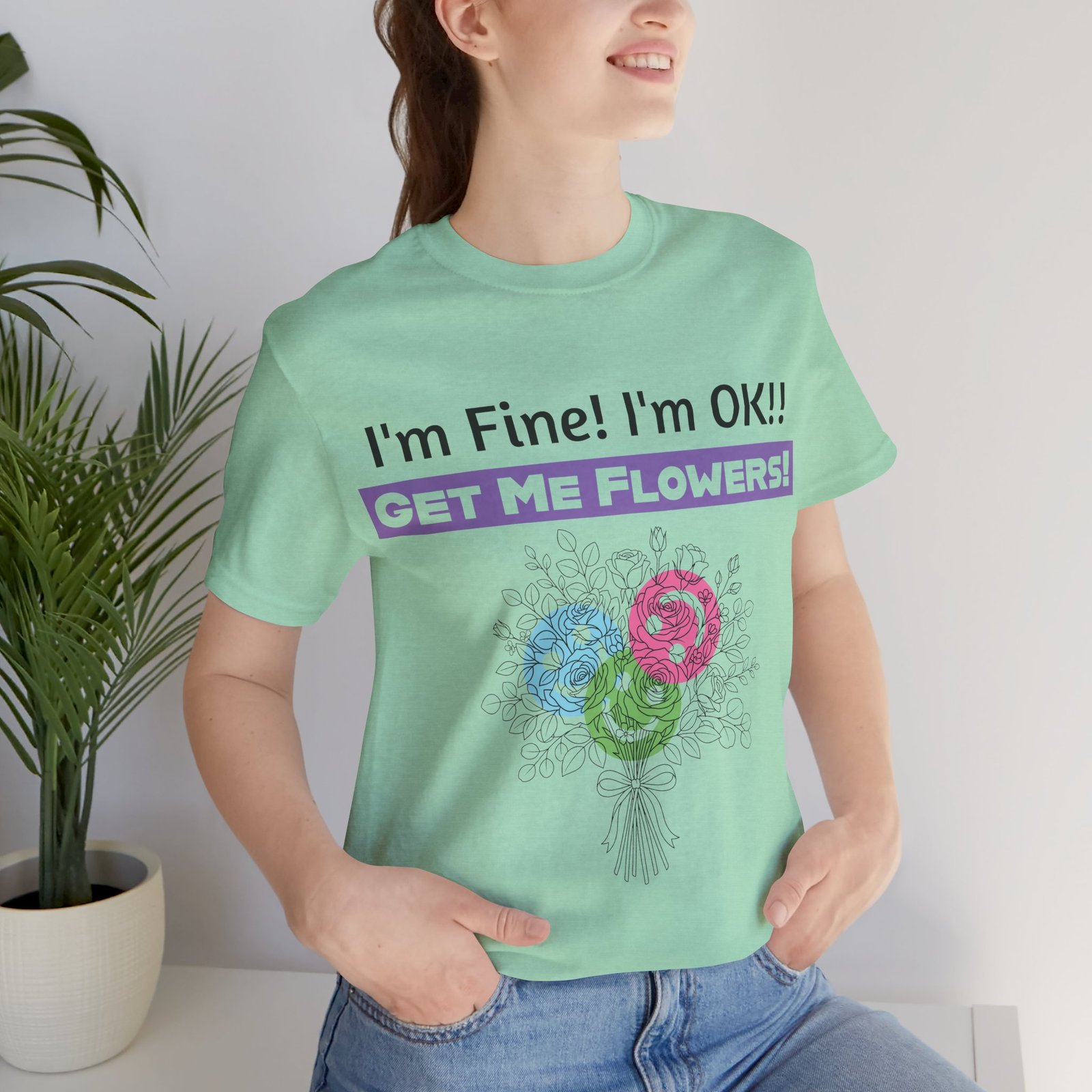 Person wearing a mint green t-shirt with a colorful floral bouquet and sarcastic text "I'm Fine! I'm OK!! GET ME FLOWERS!"
