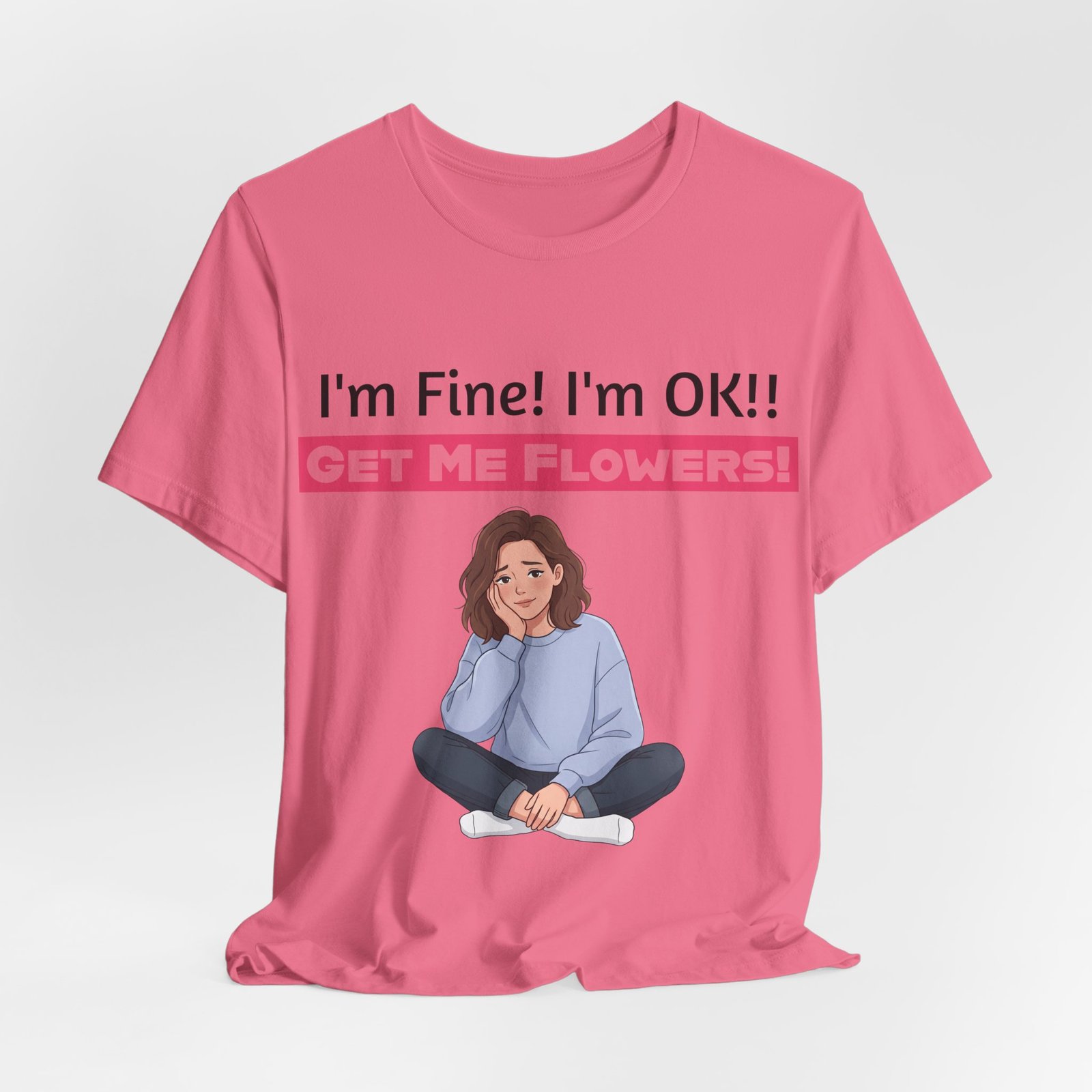 Pink crew neck t-shirt featuring a cartoon woman and humorous text: I'm Fine! I'm OK!! GET ME FLOWERS!