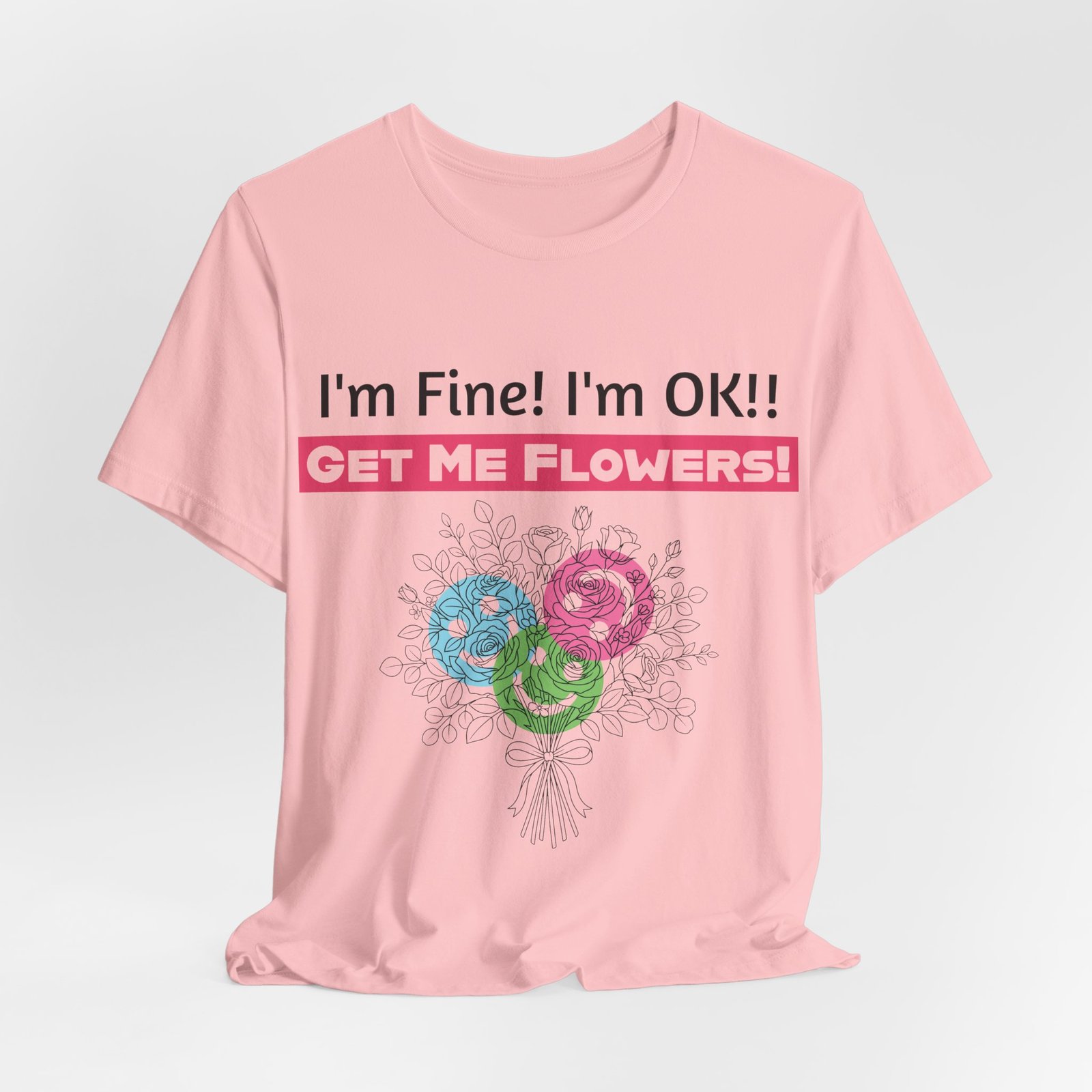 Pink crew-neck T-shirt with funny text "I'm Fine! I'm OK!! GET ME FLOWERS!" and colorful stylized floral bouquet graphic.