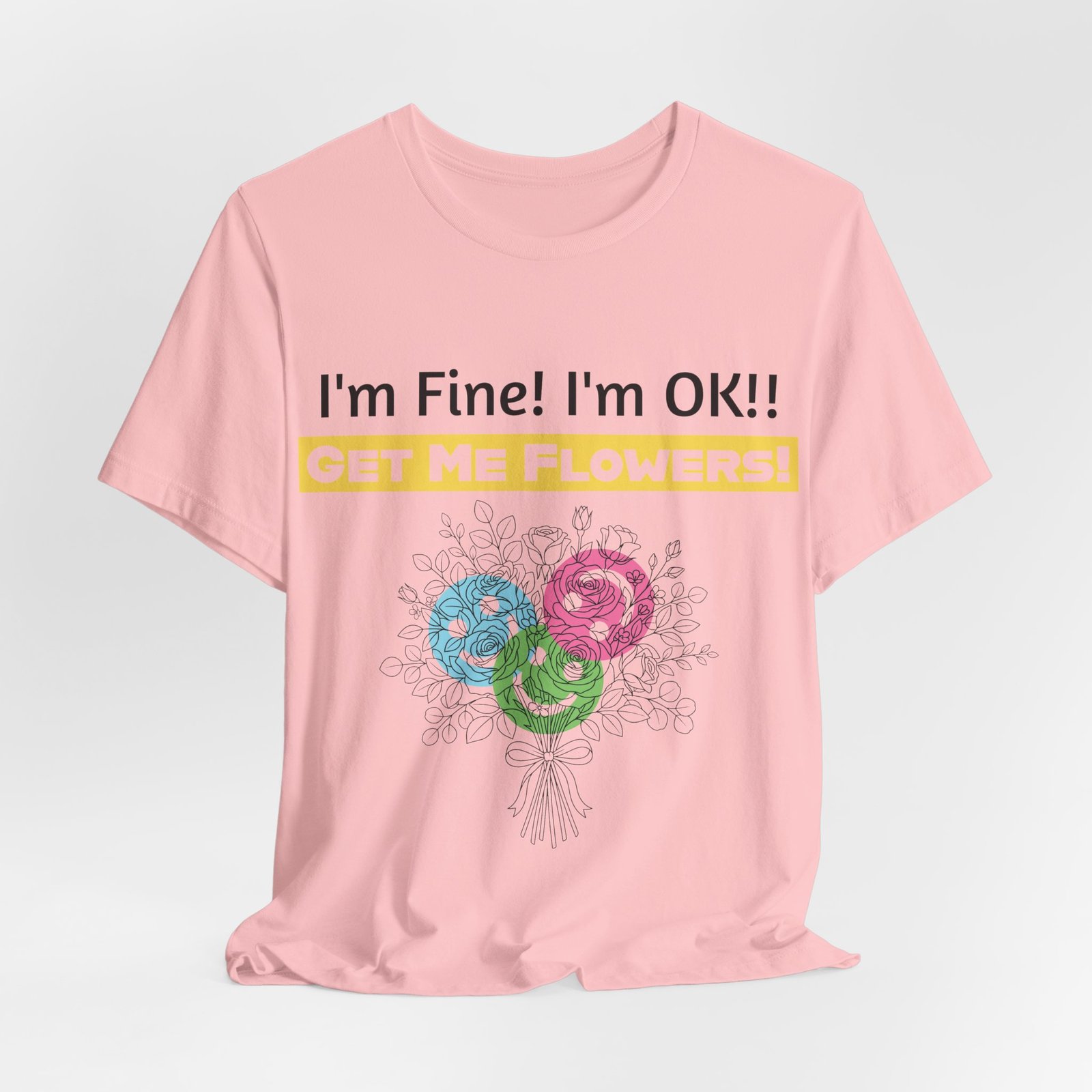 Pink crew-neck t-shirt with graphic text "I'm Fine! I'm OK!! GET ME FLOWERS!" and an abstract colorful flower bouquet.