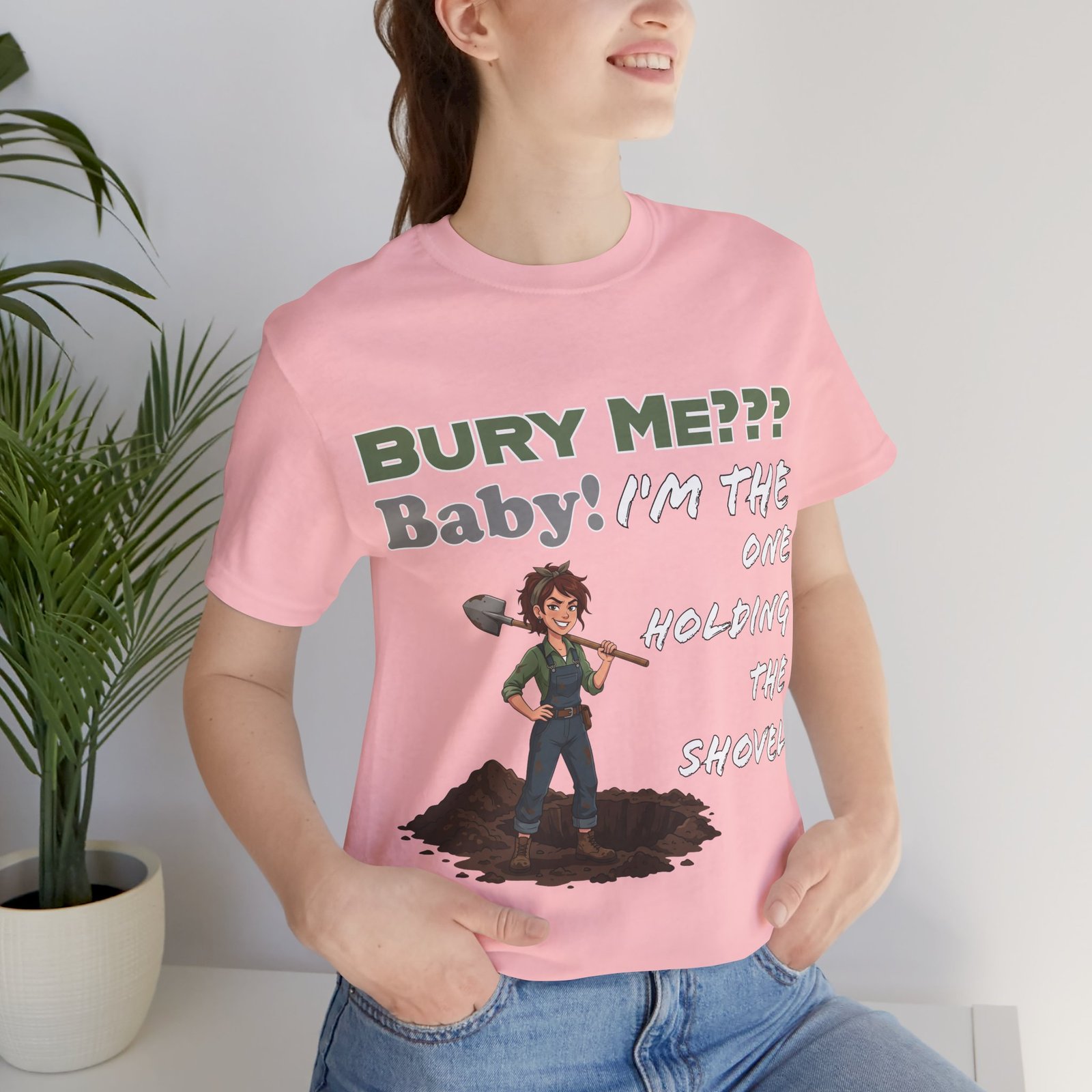 Pink t-shirt featuring a cartoon character with a shovel and the dark humor text: "Bury Me??? Baby! I'm the one holding the shovel".