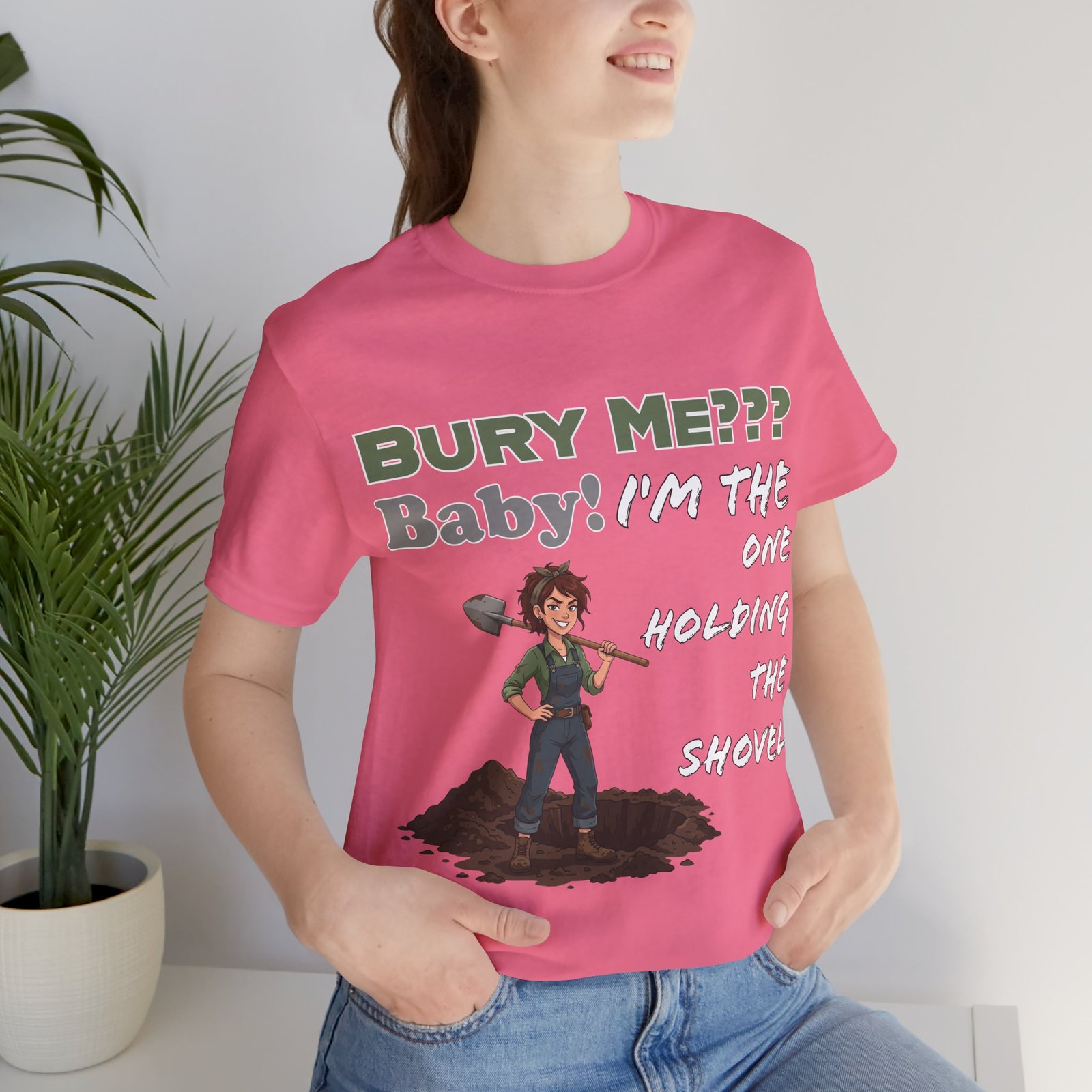 Pink T-shirt featuring a dark humor graphic of a character holding a shovel with text: Bury Me??? Baby! I'm the One Holding the Shovel