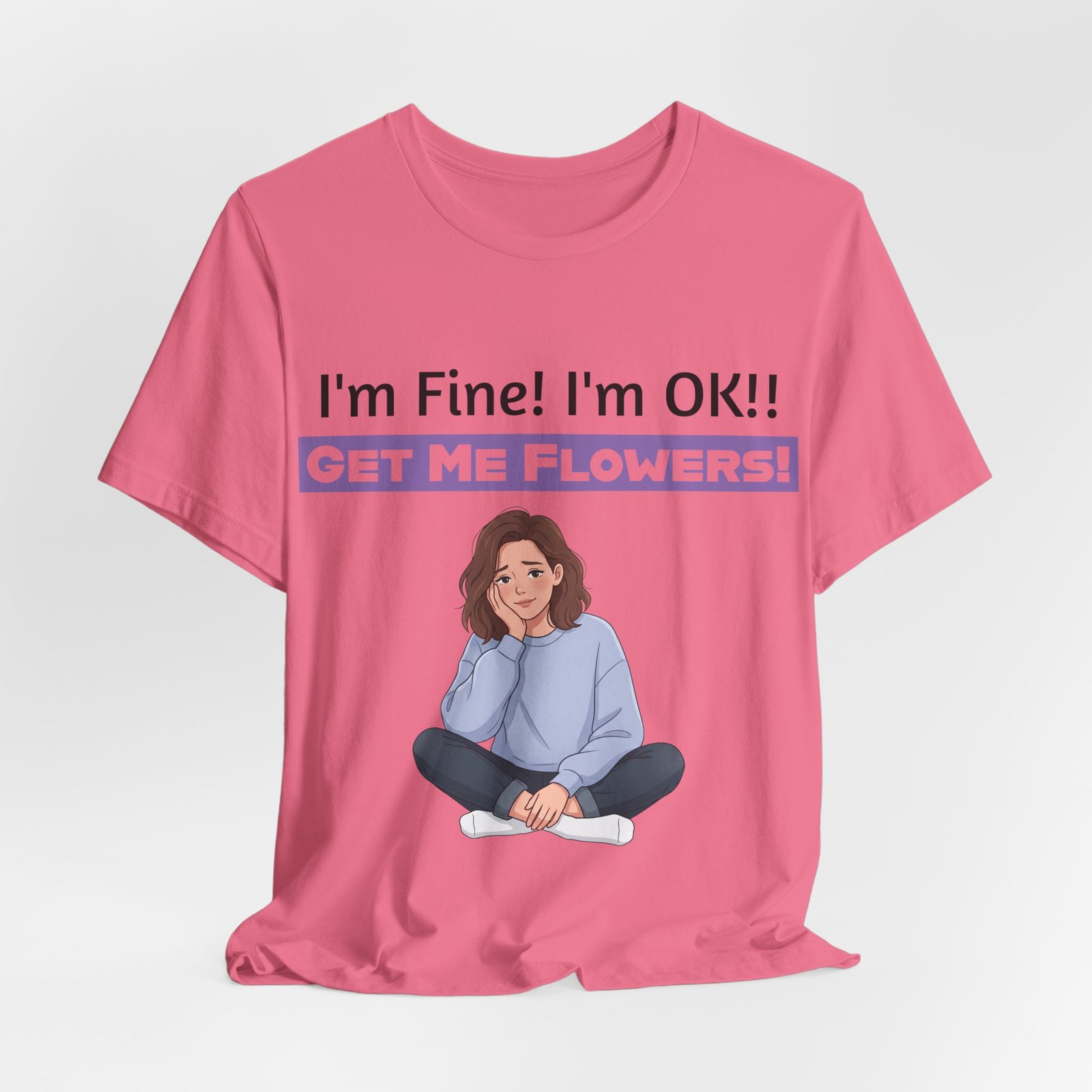 Pink t-shirt featuring a girl resting her head on her hand and the text I'm Fine! I'm OK!! GET ME FLOWERS!