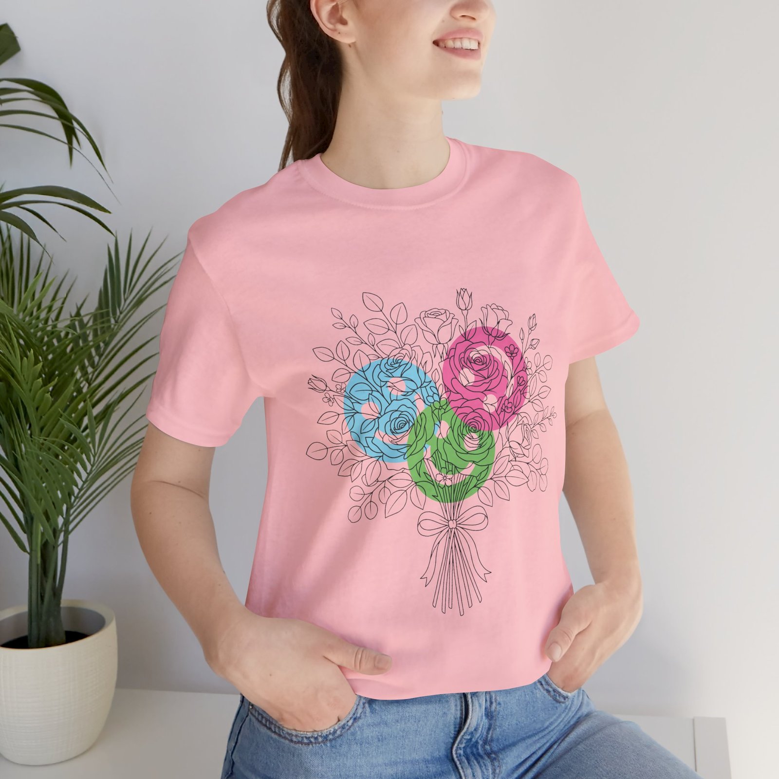 Pink T-shirt featuring a hand-drawn floral bouquet with teal, magenta, and lime spiral yarn blooms.