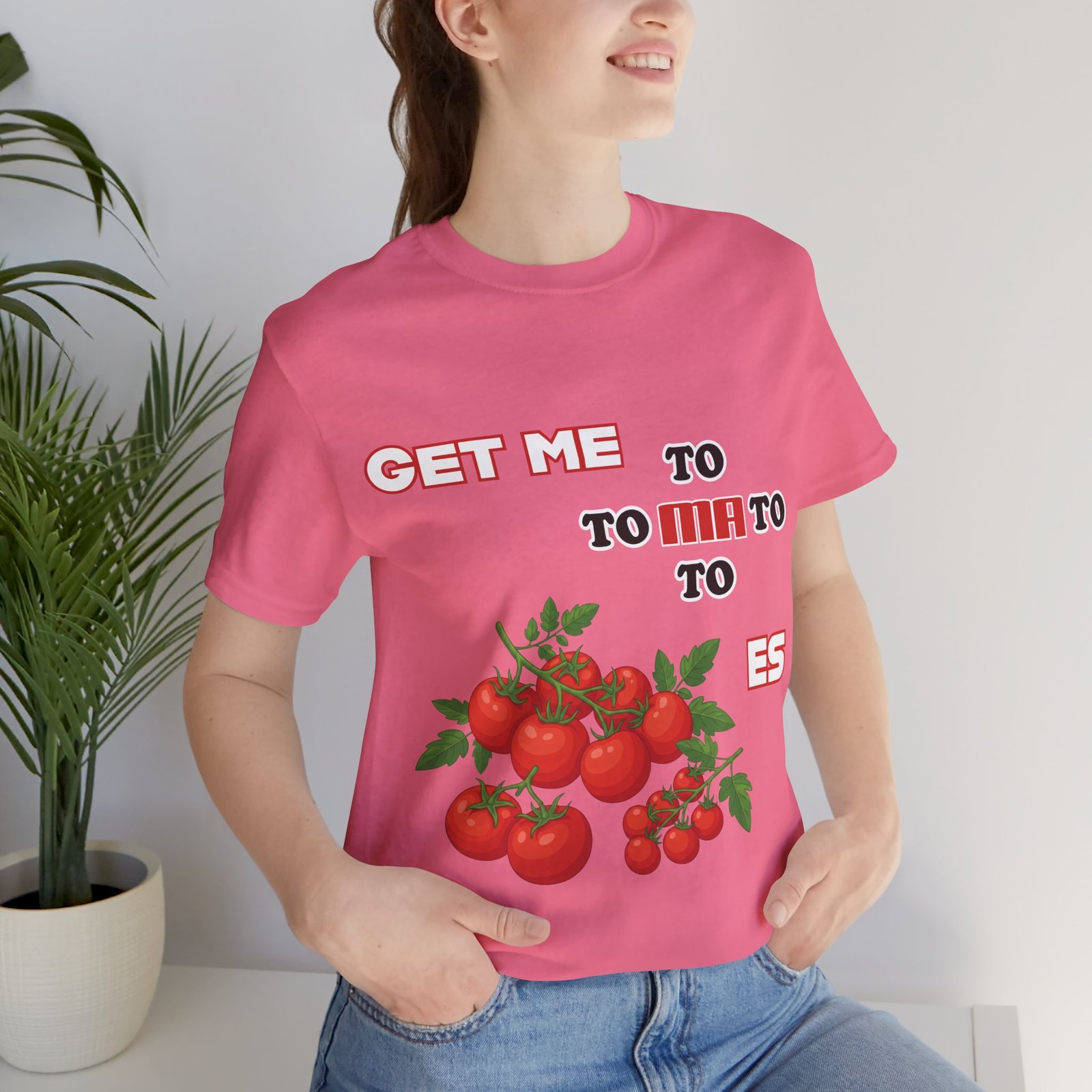 Pink T-shirt featuring a playful 'Get Me To Ma To Toes' text design and illustrated red tomato clusters.