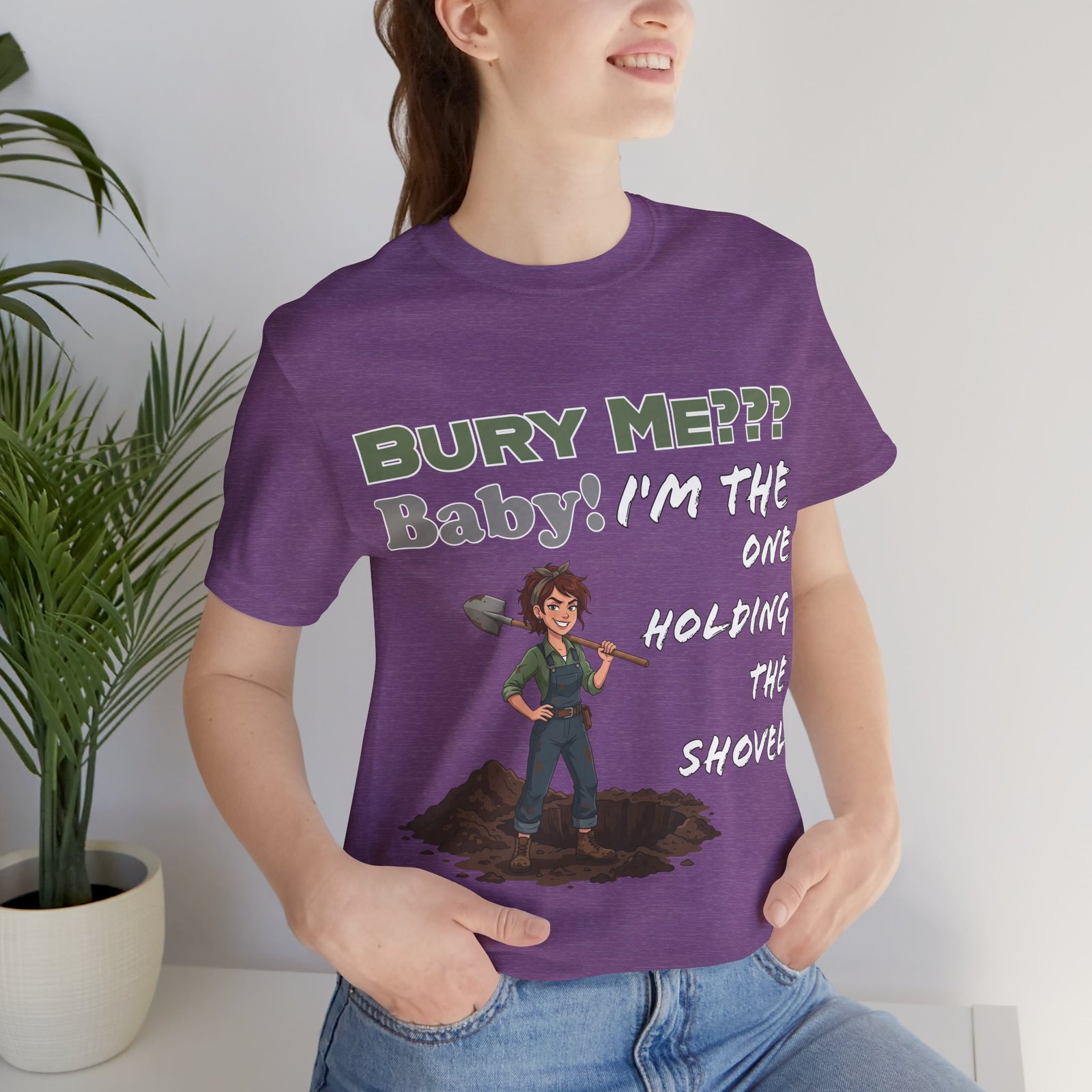Purple crew neck t-shirt featuring a dark humor illustration of a woman holding a shovel with text: Bury Me??? Baby!