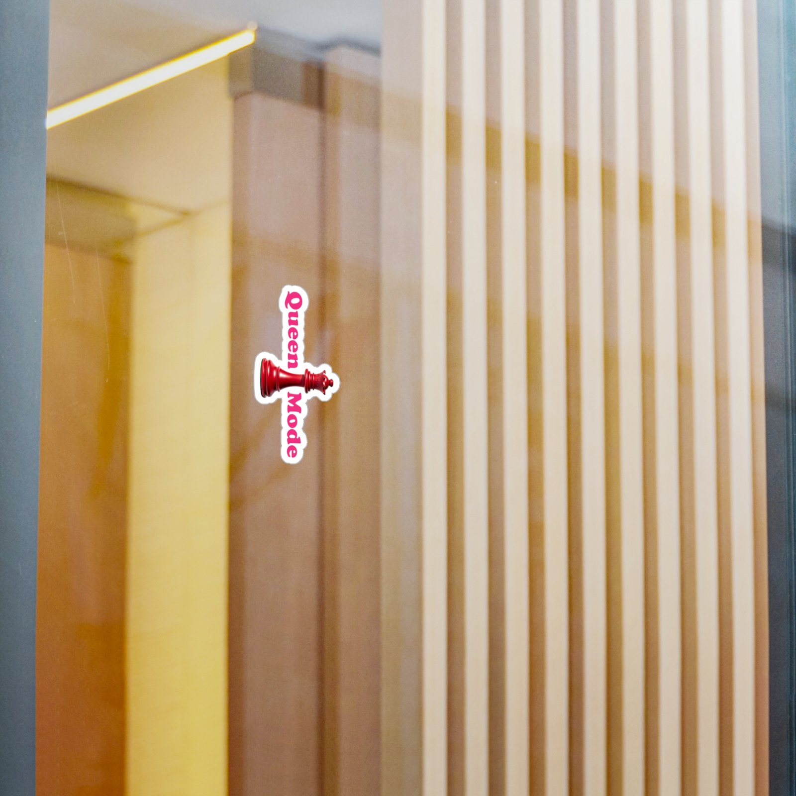 Queen Mode Red Chess Queen Sticker with vertical pink text and a white border on a glass surface.
