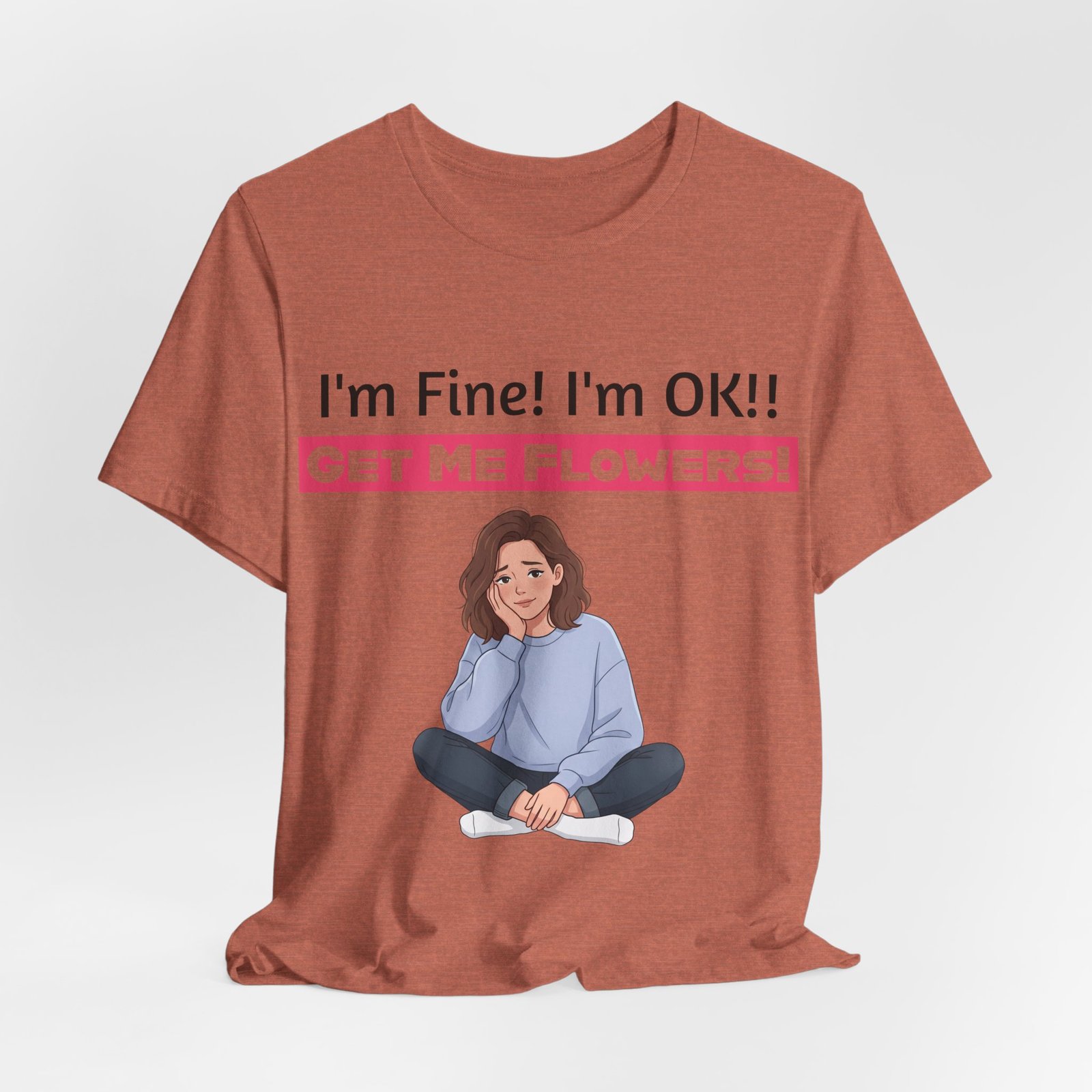 Rust-colored funny t-shirt featuring an illustration of a weary person and the text I'm Fine! I'm OK!! GET ME FLOWERS!