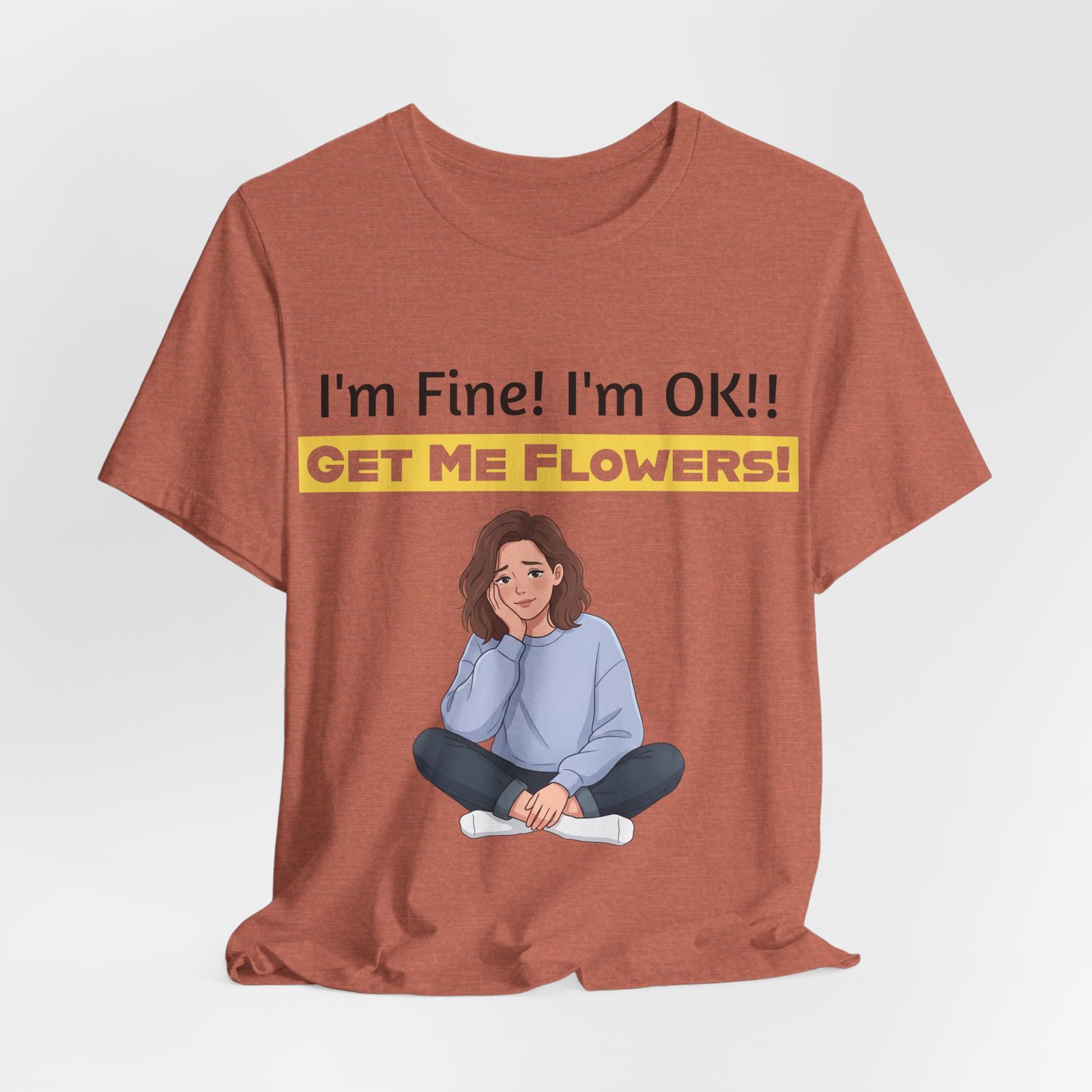 Rust-colored t-shirt featuring a cartoon woman sitting cross-legged and text reading I'm Fine! I'm OK!! GET ME FLOWERS!