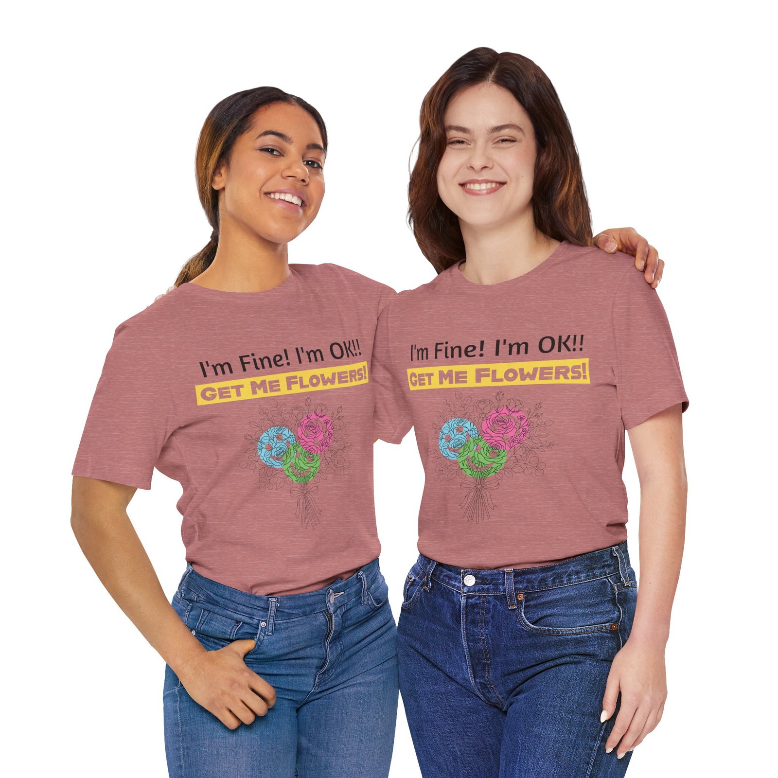 Two women smiling while wearing pink crew-neck t-shirts featuring the text "I'm Fine! I'm OK!! GET ME FLOWERS!" and colorful blooms.