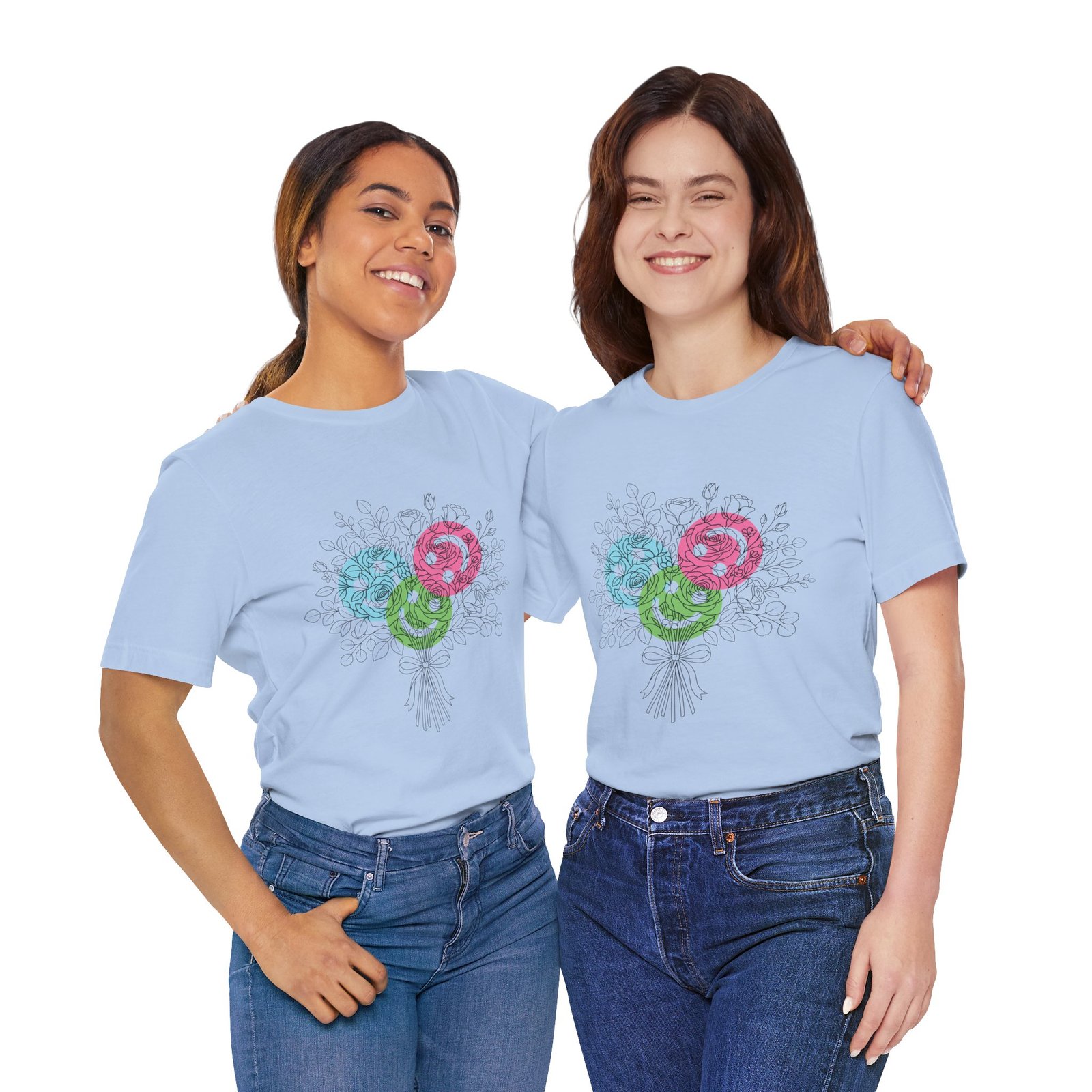 Two women wearing light blue T-shirts featuring a colorful floral yarn bouquet with teal, magenta, and lime blooms.