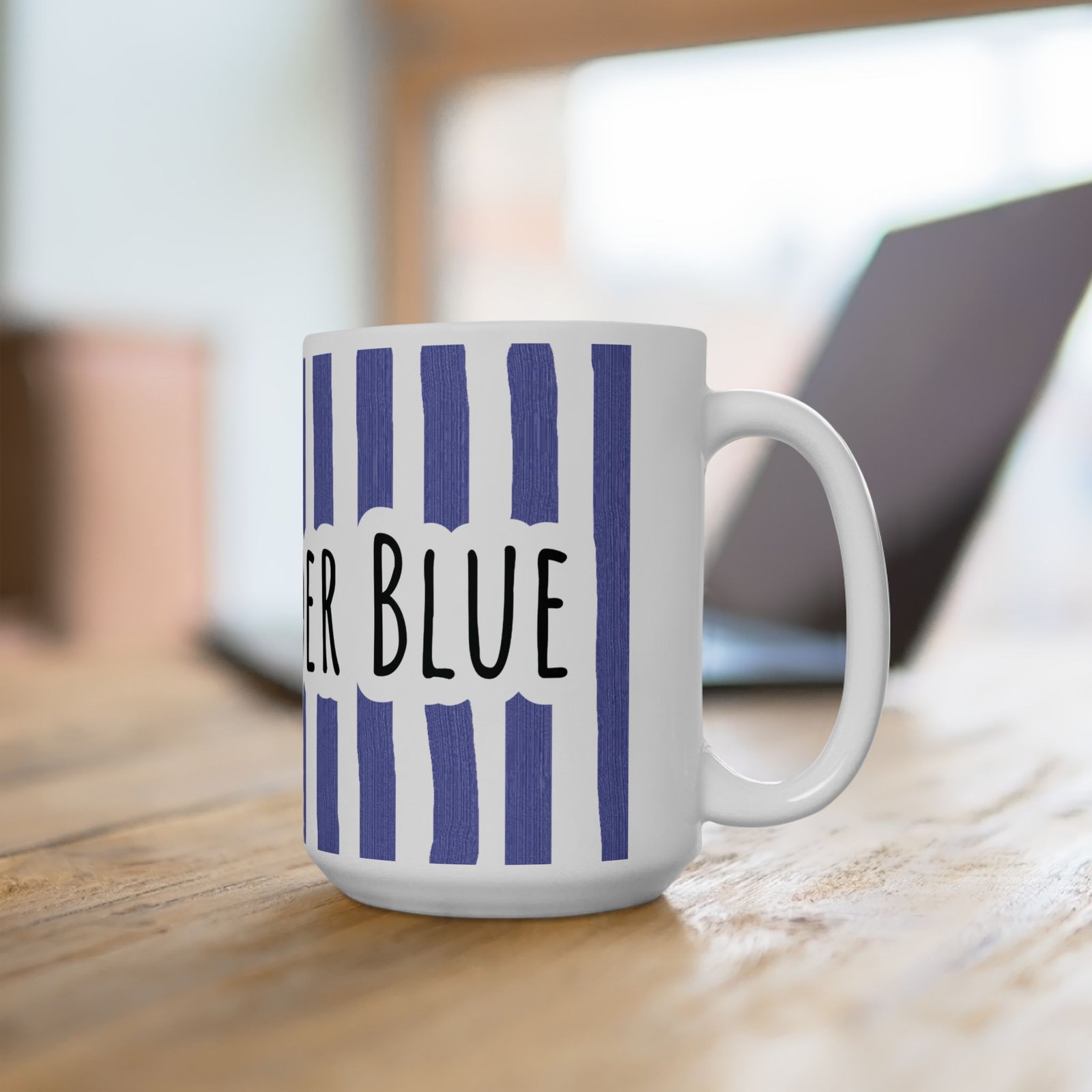 White ceramic mug featuring vertical periwinkle brushstroke stripes and hand-lettered 'STAY UNDER BLUE' text.