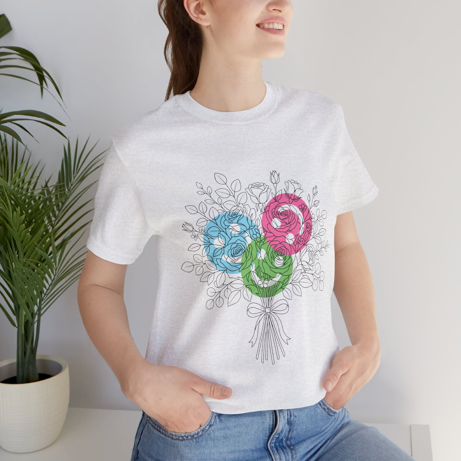 White t-shirt featuring a hand-drawn bouquet with three colorful teal, magenta, and lime spiral yarn flower blooms.