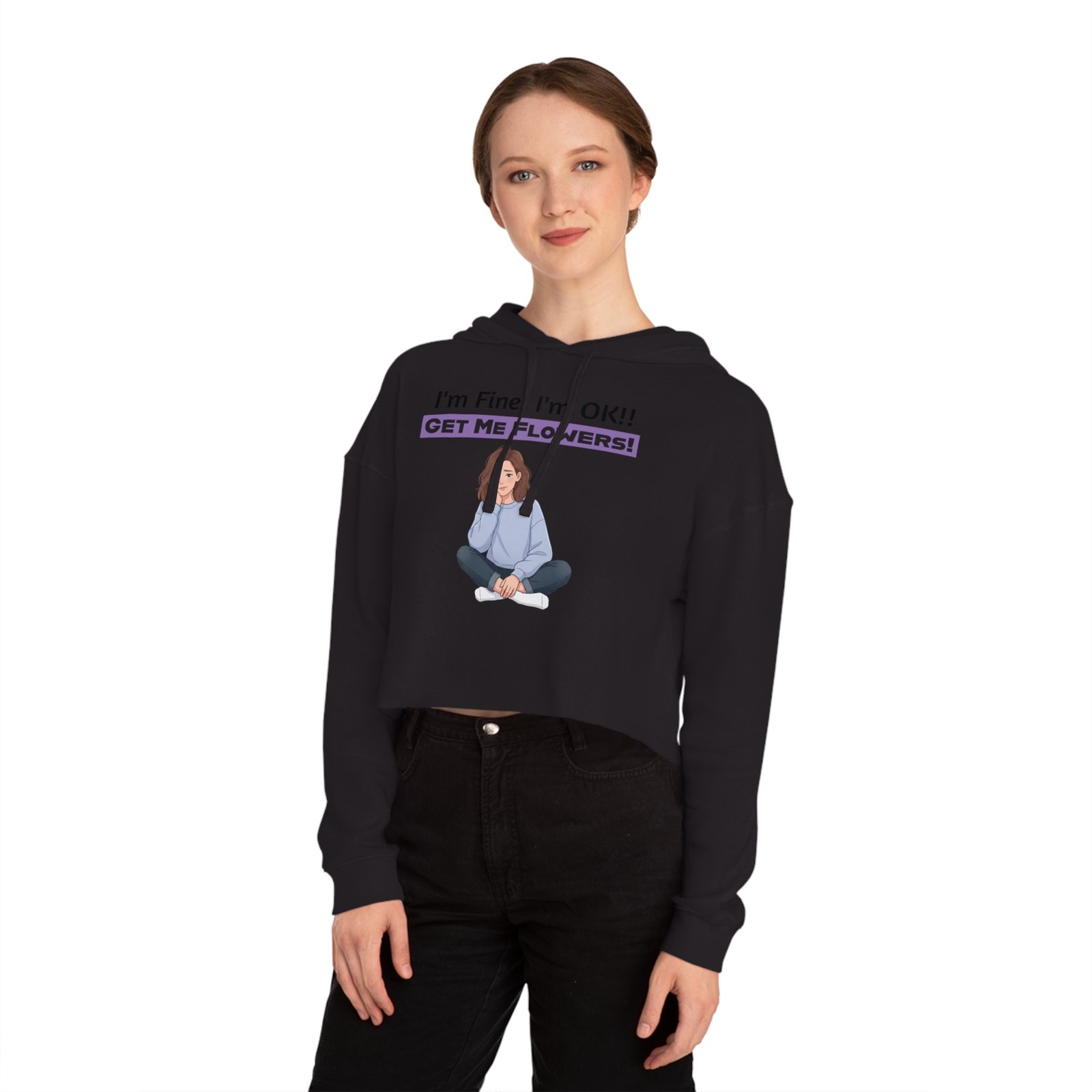 Woman wearing a black cropped hoodie with a graphic of a girl and the text I'm Fine! I'm OK!! GET ME FLOWERS!