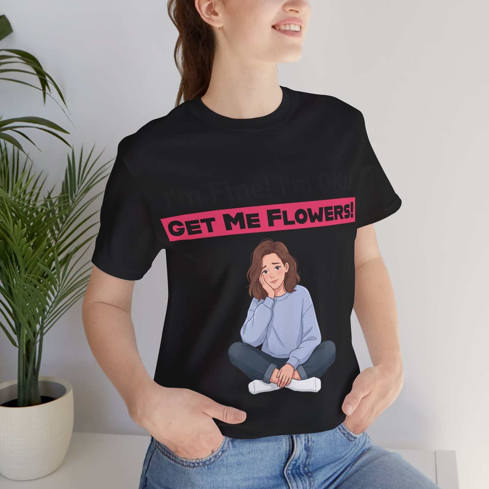 Woman wearing a black 'I'm Fine! I'm OK!! Get Me Flowers!' funny graphic t-shirt featuring a cartoon illustration.