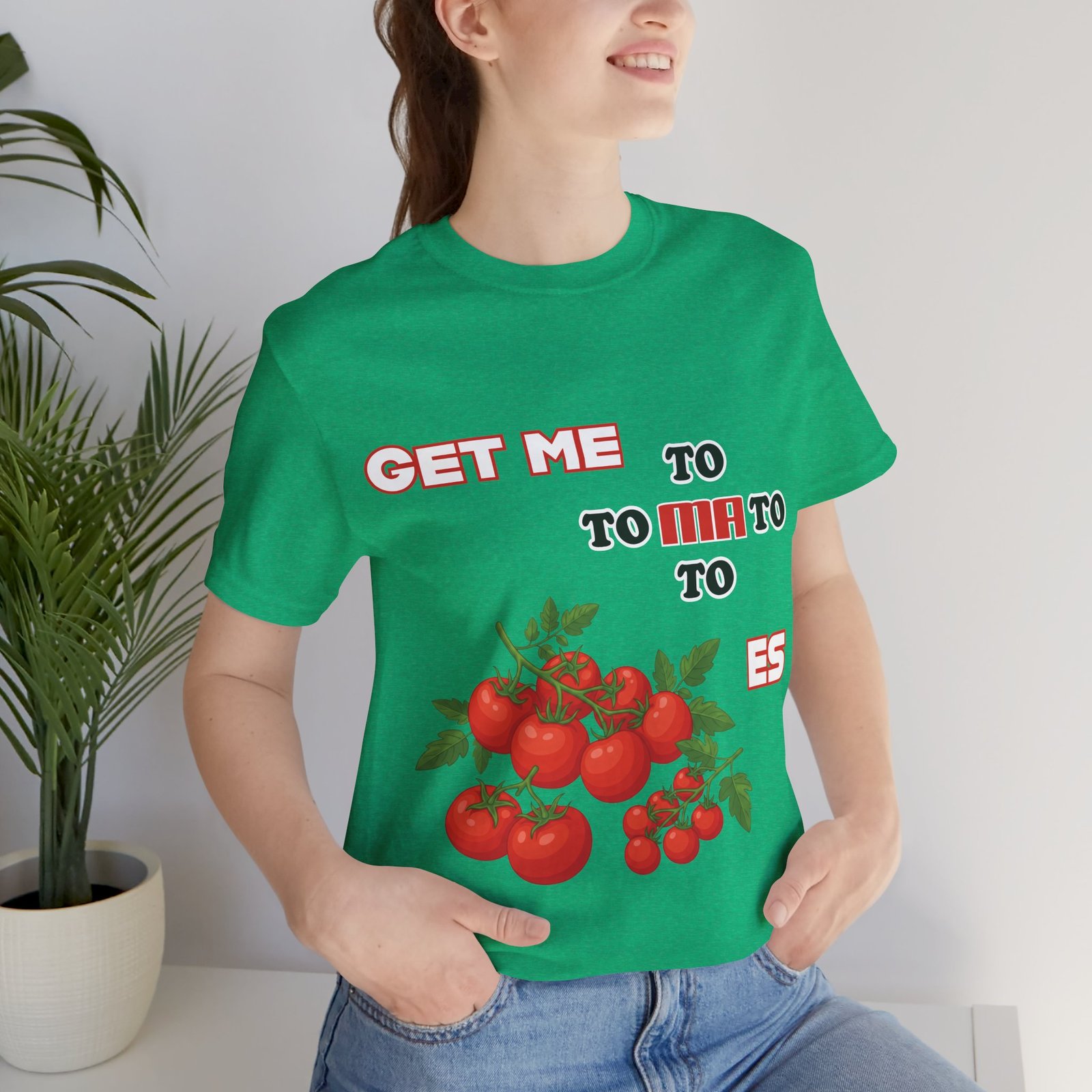 Woman wearing a green Get Me To Ma To Toes T-shirt featuring a vintage tomato illustration and retro text.