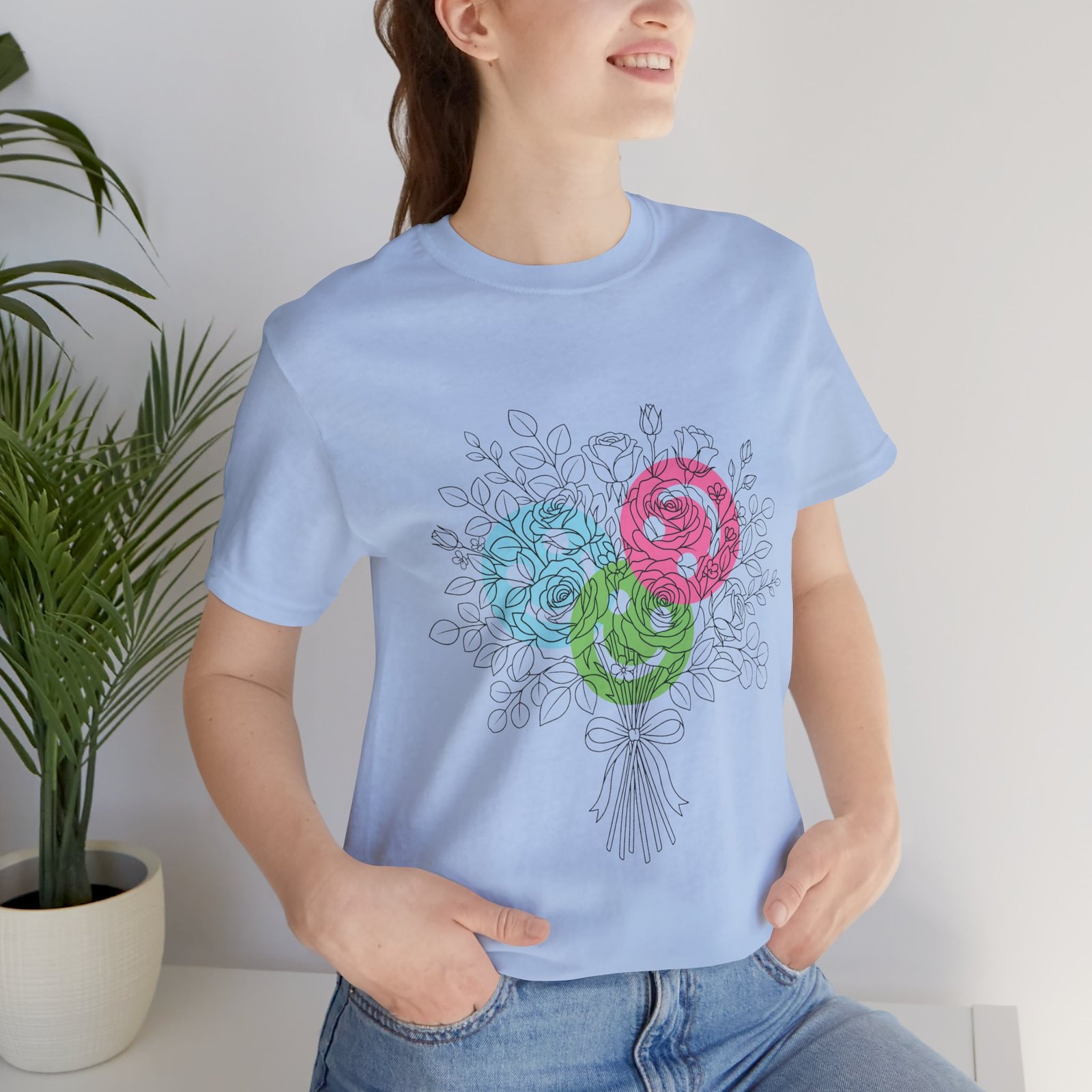 Woman wearing a light blue T-shirt featuring a hand-drawn bouquet with teal, magenta, and lime spiral floral blooms.