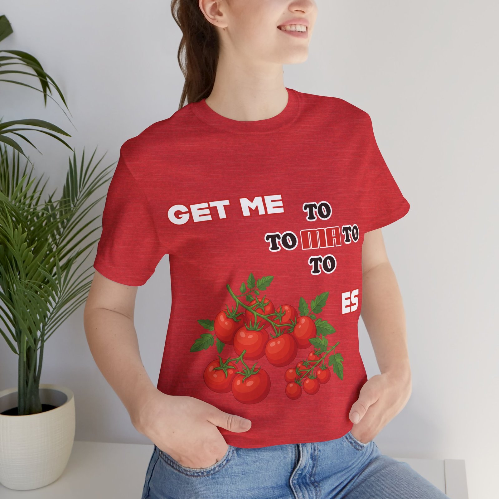 Woman wearing a red Get Me To Ma To Toes T-shirt featuring vintage tomato illustrations and bold white text.