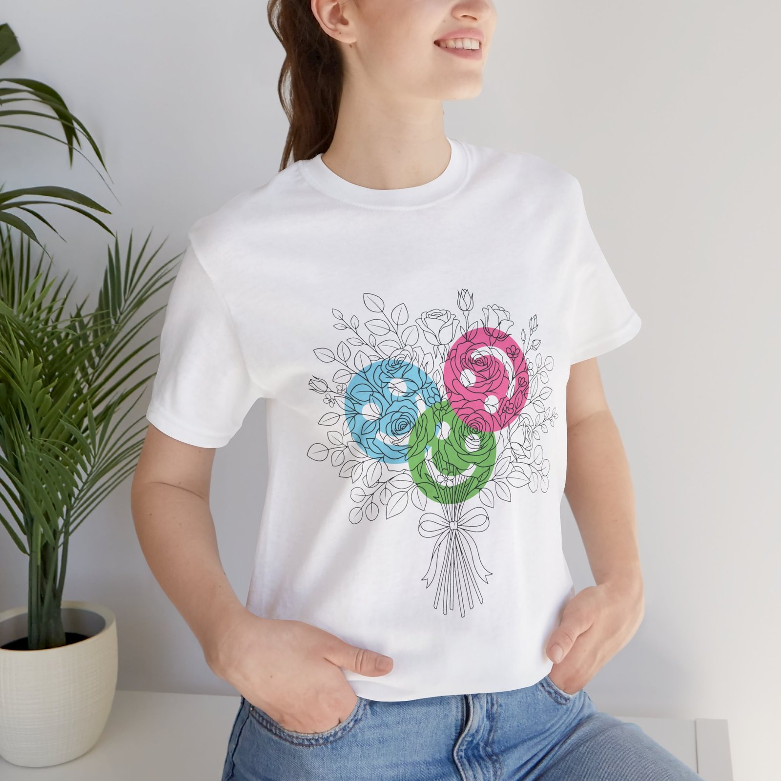 Woman wearing a white Floral Yarn Bouquet T-Shirt featuring colorful teal, magenta, and lime spiral flower doodles.