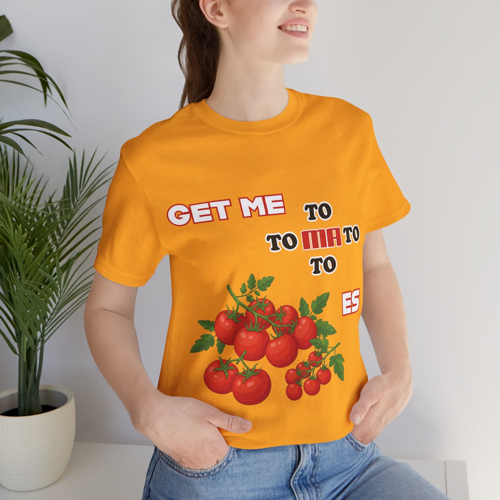 Woman wearing an orange 'Get Me To Ma To Toes' vintage t-shirt featuring red tomato illustrations.