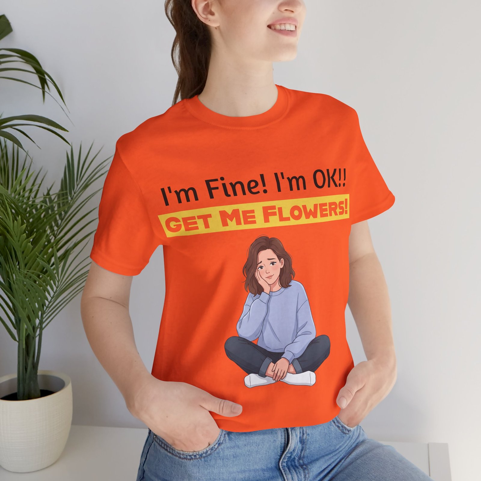 Woman wearing an orange I'm Fine! I'm OK!! Get Me Flowers! Funny T-Shirt featuring an illustration of a relaxed girl.