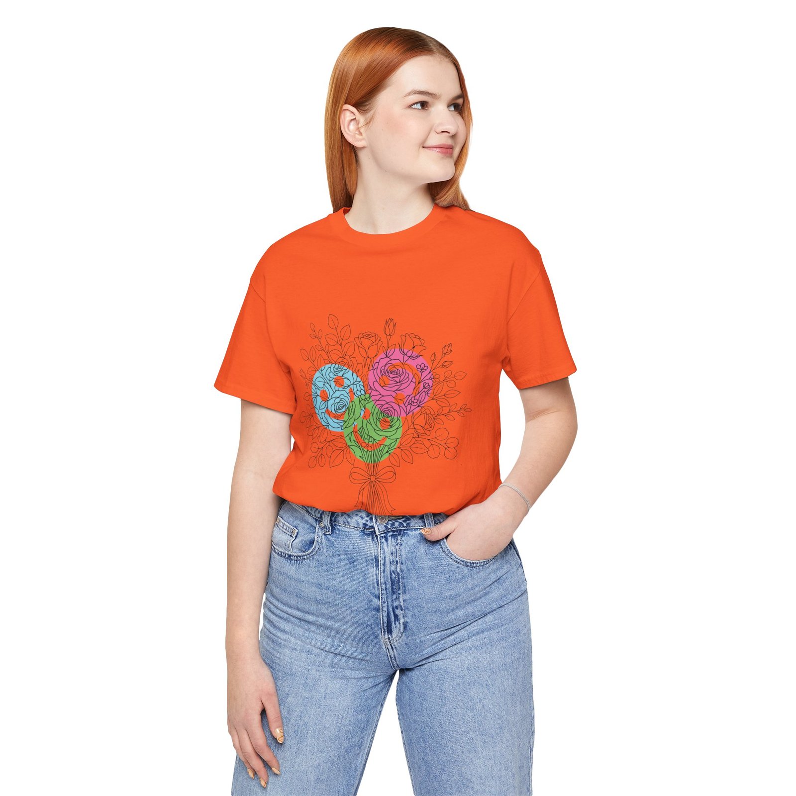 Woman wearing an orange t-shirt with a colorful teal, magenta, and lime floral yarn bouquet graphic.