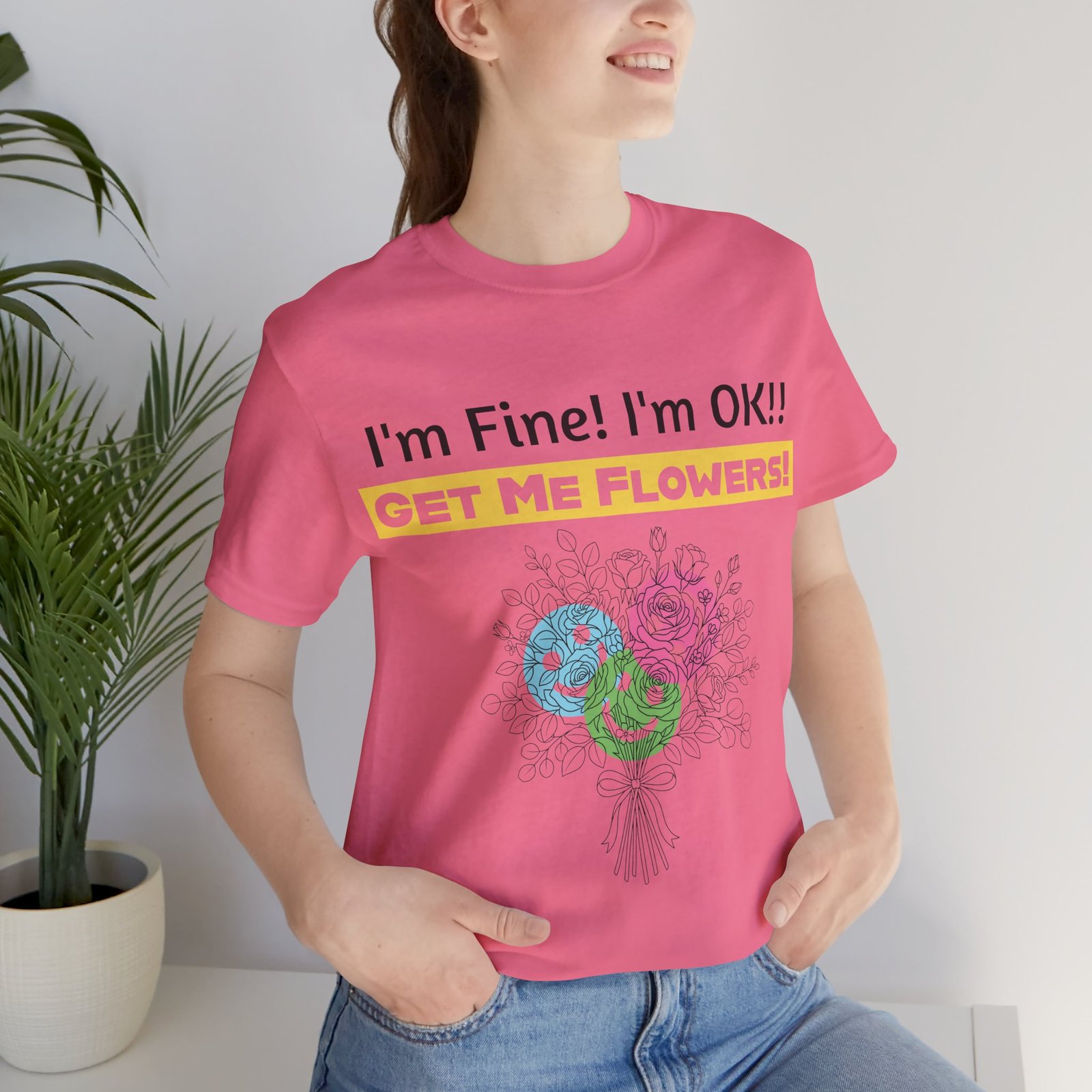 Woman wearing pink Bella+Canvas tee with funny I'm Fine! I'm OK!! Get Me Flowers! graphic and colorful floral bouquet.