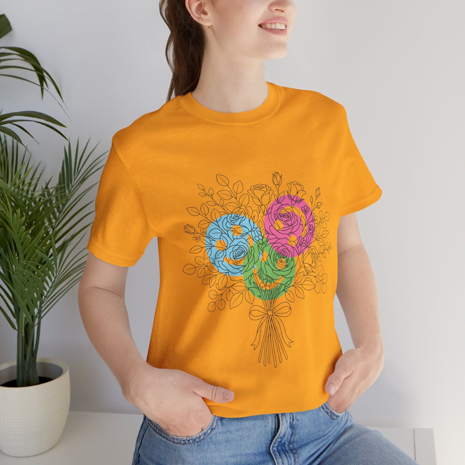 Yellow t-shirt featuring a hand-drawn bouquet of teal, magenta, and lime floral yarn blooms.